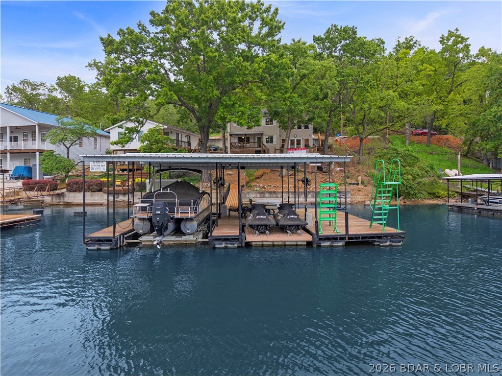 Finding the perfect combination of no-wake cove protection, deep water, and a gentle, non-steep lot is nearly impossible—until now. Welcome to 29966 Oak Knoll, a turnkey retreat at the 5-mile marker that checks all the boxes. This 3-bedroom, 3-bath gem blends rustic charm with modern updates. You’ll love the custom wood "tongue and groove" ceilings and the massive country-inspired kitchen designed for hosting family and friends alike, all while viewing those gorgeous lake vistas. Recent upgrades include windows, a new roof in 2019, an HVAC system, living room flooring, a public sewer, and an updated electrical panel, providing peace of mind. Step outside to the expansive lakeside deck and take the rare, easy stroll to your private dock. The lot faces southwest, avoiding the direct hot summer sun. Whether you’re fishing, swimming, jet skiing, boating, or heading to nearby entertainment hotspots, this fully furnished home is ready for lake life on day one. Easily accommodates 3 vehicles, with overflow parking on the roadside. Pictures do not do this one justice, so set up your personal tour today.