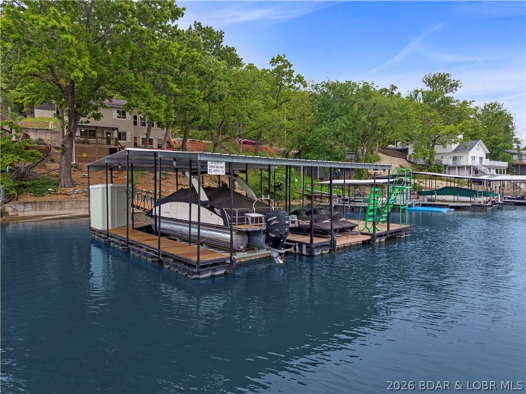 Finding the perfect combination of no-wake cove protection, deep water, and a gentle, non-steep lot is nearly impossible—until now. Welcome to 29966 Oak Knoll, a turnkey retreat at the 5-mile marker that checks all the boxes. This 3-bedroom, 3-bath gem blends rustic charm with modern updates. You’ll love the custom wood "tongue and groove" ceilings and the massive country-inspired kitchen designed for hosting family and friends alike, all while viewing those gorgeous lake vistas. Recent upgrades include windows, a new roof in 2019, an HVAC system, living room flooring, a public sewer, and an updated electrical panel, providing peace of mind. Step outside to the expansive lakeside deck and take the rare, easy stroll to your private dock. The lot faces southwest, avoiding the direct hot summer sun. Whether you’re fishing, swimming, jet skiing, boating, or heading to nearby entertainment hotspots, this fully furnished home is ready for lake life on day one. Easily accommodates 3 vehicles, with overflow parking on the roadside. Pictures do not do this one justice, so set up your personal tour today.