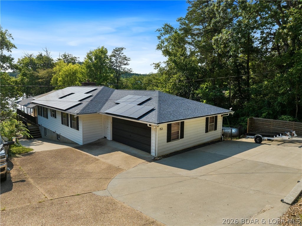 Attention Investors! Lake of the Ozarks multi-family retreat. Serious rental income or perfect for extended family and multi-generational living.  Live On One Level, Rent the Other. Conveniently located, this fully furnished 4,400+ sq ft property features two complete living spaces- one per level - each with its own large kitchen, dining area, and 4 spacious bedrooms. The newer septic is a comfort.  The fact that it is solar powered, allows you to live in comfort for less than $50. a month for electricity. Step outside to enjoy lake living at its finest: on a  brand-new 46x50 dock with two 12x30 slips and a 12x12 PWC slip plus 8x10 dock locker, a huge swim platform, and a covered entertainment area made for large gatherings. Relax on the upper deck or lower patio after a day on the water. Newer septic, 2-car garage, and all the details handled. With rentals already in demand - golfers, fishermen, baseball families, and Lake of the Ozarks vacationers - this property is a cash-flow machine and a forever family compound all in one. Located very near Lake Valley, Old Kinderhook, and Ha Ha Tonka. Your lake house – your investment – your lifestyle. Do not miss out on seeing this one.