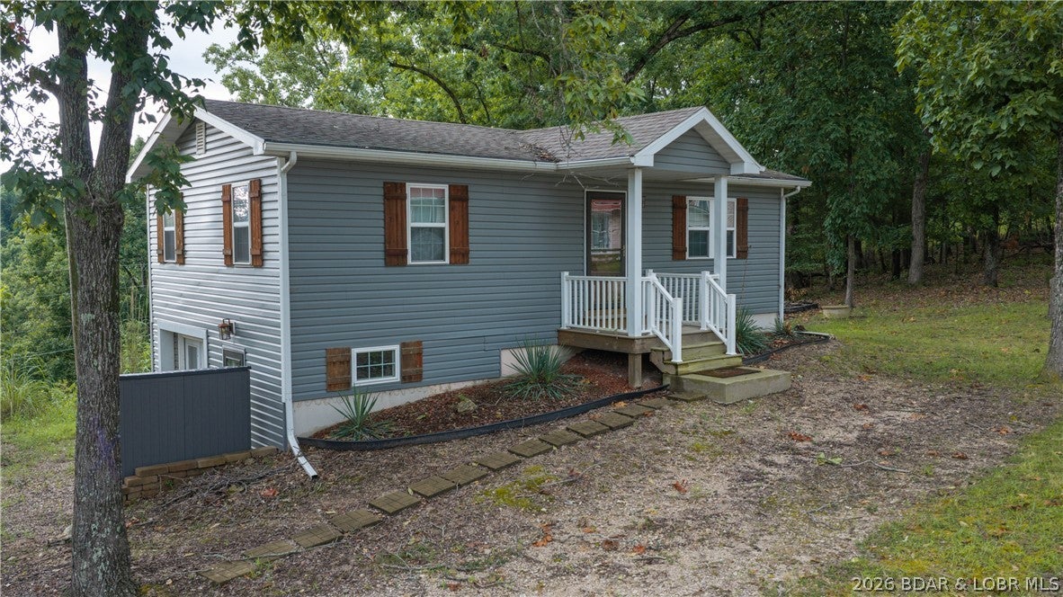 Lake access, a private boat slip, rental potential, and room to add value—this second-tier Lake of the Ozarks property offers a lot at an approachable price point. The 2-bedroom, 1-bath home sits on approximately .7 acres and features an unfinished basement with the potential to expand the home to 3 bedrooms and 2 baths. Just a half-mile drive away, the community dock is tucked into a calm, wide cove and includes your private 10x20 boat slip and dock locker. Next to the dock, enjoy a martini deck overlooking the community swim dock—perfect for taking in the lake views, swimming, fishing, or relaxing by the water. The spacious property also provides room for a future garage, additional parking, or outdoor improvements. Conveniently located just minutes from town, groceries, restaurants, and popular lake destinations. Nightly rentals are allowed, making this a great option for a full-time residence, weekend getaway, or investment property. Schedule your showing and start enjoying lake life!