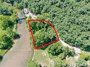 Rare opportunity to own a unique Lake of the Ozarks property combining 18 unrestricted acres with a 0.70-acre waterfront lot along the crystal-clear, spring-fed Bank Branch River. Surrounded by the beauty of Ha Ha Tonka State Park, this property offers incredible privacy, mature timber, abundant wildlife, lake views, and direct water access. With no HOA or building restrictions on the 18 acres, build your dream home, barndominium, family retreat, or recreational getaway. The waterfront lot is approved for up to a 3-bedroom home and includes access to a 0.75-acre utility lot, offering potential for an additional well and septic system to accommodate a larger home. Small boats, kayaks, and canoes can access the Lake of the Ozarks, with exceptional fishing right from the shoreline. A home built above the 668-foot elevation does not require flood insurance. A 15-foot river access easement for upper lots runs along the far north edge. Whether you're looking for a full-time residence, vacation retreat, recreational property, or investment, this is an exceptional opportunity to own waterfront plus acreage in one of the Lake area's most scenic settings.