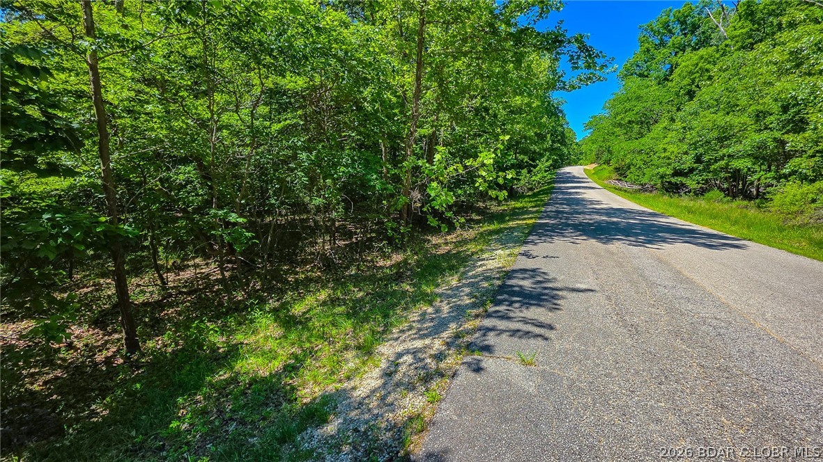 Premier Level Lot in Prestigious Porto Cima! Build your dream home or next investment property on this beautiful, level lot located on Spring Creek Drive in one of the Lake of the Ozarks' most sought-after communities. Boasting a highly desirable level terrain that minimizes site prep and foundation costs, this maturely wooded property comes build-ready with water and sewer agreements already firmly in place. The lot backs up to community-owned land featuring a peaceful seasonal creek, ensuring excellent privacy and a serene natural backdrop. As part of the Porto Cima community, you’ll enjoy access to a premier lake lifestyle with a robust amenities package, including community pools, playgrounds, a fitness center, and lake access, all just moments away from world-class golfing and dining. Bring your builder and start planning your ultimate lake-area retreat today!