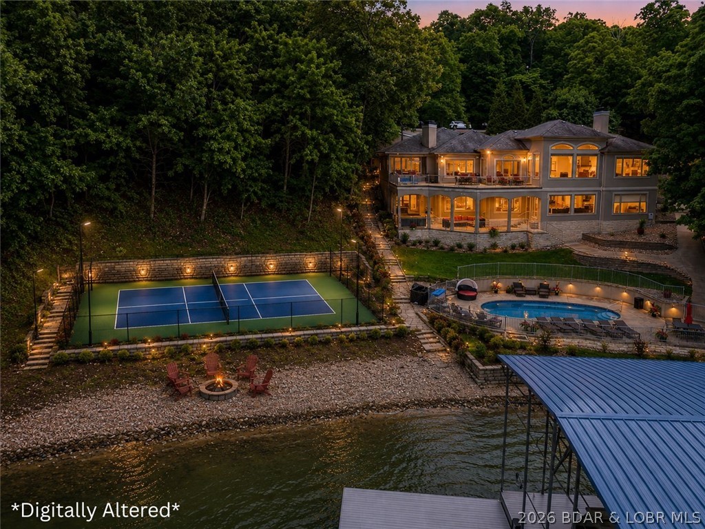 RARE OPPORTUNITY! Coming soon, the seller is adding a private pickleball court on the adjacent lot, creating one of the Lake’s most unique lakefront properties with an amenity rarely found at a private residence, especially on the water. Wake up to sweeping channel views and end your evenings surrounded by privacy in this updated Thomas Construction home, perfectly positioned on nearly an acre with 168’ of lakefront in one of the Lake’s most sought after locations. Completely updated in 2023, this 5 bedroom, 4.5 bath home was designed for luxury living and entertaining with only 2 levels instead of 3, allowing for large gathering spaces throughout. Quality craftsmanship shines from the soaring 16’ ceilings and trim work to the hickory engineered hardwood floors, four fireplaces throughout the home including one on the screened porch, and a gourmet kitchen featuring custom knotty alder cabinetry and high end appliances. The spacious primary suite offers a spa inspired bath with copper soaking tub, oversized walk in closet, and laundry access. The lower level features a full bar and second laundry area, perfect for hosting guests. Outside, enjoy the new 2 slip dock and pool too.