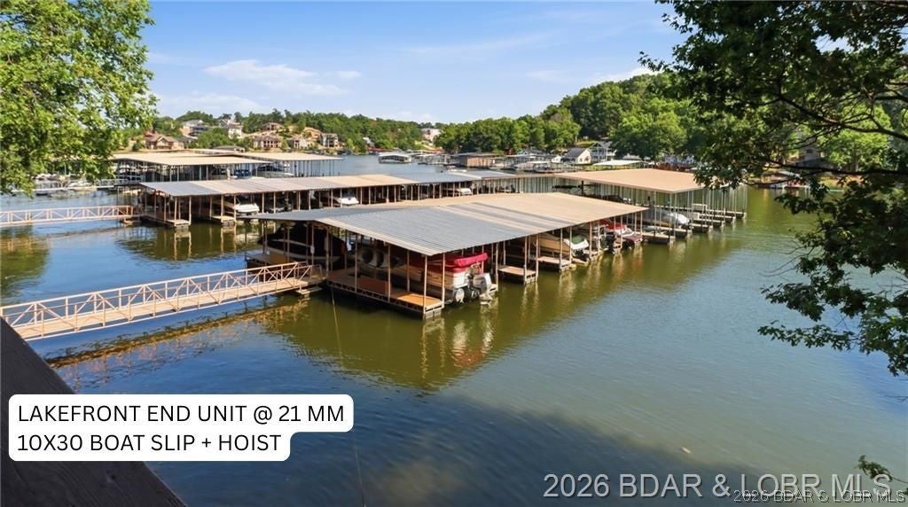 Enjoy lakefront living in this spacious end-unit condo at The Knolls, one of Osage Beach's most amenity-rich communities! With 1,552 SqFt, 2-bedrooms, 2-bathrooms, and a versatile bonus room that can function as an additional bedroom, office, or guest space - this condo offers far more flexibility than a typical 2-bed unit. The open living area features a cozy fireplace, built-in shelving, and access to the covered deck, creating an easy indoor-outdoor flow for relaxing, entertaining, or enjoying a weekend at the lake. A 10x30 boat slip with hoist is included, giving the next owner convenient and direct lake access. Located at the 21 Mile Marker, you are just a short boat ride away to popular lakefront destinations including Redhead Lakeside Grill, Shorty Pants, Backwater Jacks, Dog Days and the upcoming Oasis Amusement Park. The Knolls offers a strong amenity package, including indoor/outdoor pools, fitness center, indoor/outdoor tennis courts, clubhouse, playground, onsite boat ramp, trailer parking, and gathering spaces for family and guests. The HOA also includes services such as Cable/Internet, Sewer, Water, and Trash! ** MOTIVATED SELLER**