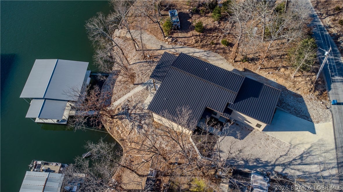 Welcome to luxury lakefront living with this contemporary home, custom-built in 2022 and situated on a lot in a prime Osage Beach location. This ~3,900 sq ft masterpiece features 6 bedrooms, 4 full baths, 2 half baths, and an oversized 2-car garage with a sleek standing seam metal roof. Designed with premium finishes throughout and offered turnkey in a calm, protected cove. The standout feature is the private living quarters, complete with its own entrance, kitchen, walkout, and laundry—perfect for potential Airbnb rental income, mother-in-law quarters, or accommodating extended family. Steps away you’ll find a custom-built 3-slip boat dock (14×40, 12×40, 12×18) situated in deep water for year-round lake access. The gently sloping lot provides easy access to the dock and lake. The home is equipped with 400-amp service, 100 amps dedicated to the dock, and a 50-amp EV charging plug in the garage.