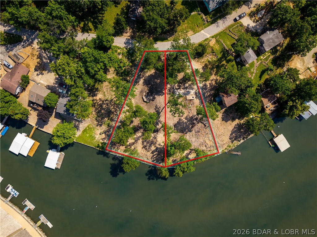 Rare opportunity to build your dream lakefront home in one of the most desirable areas of Lake of the Ozarks! This exceptional lot offers over 100 feet of lake frontage and gentle topography, making the building process easier and more cost-effective while providing excellent access to the waterfront. Enjoy deep water, ideal for boating, swimming, and year-round dock use. Conveniently located at the 14 MM, this property offers the perfect blend of privacy and accessibility. By water, you're just minutes from many of the lake's most popular waterfront restaurants, entertainment destinations, and attractions. By land, you'll appreciate the quick access to shopping, dining, golf, and everyday conveniences. City water and sewer are available, eliminating many of the challenges often associated with lakefront construction. Whether you're envisioning a full-time residence, vacation getaway, or future investment property, this lot provides the ideal setting to bring your vision to life. With over 100 feet of lake frontage, deep water, gentle terrain, and a prime central location, this is a rare opportunity to create the custom lake home you've always wanted at Lake of the Ozarks.
