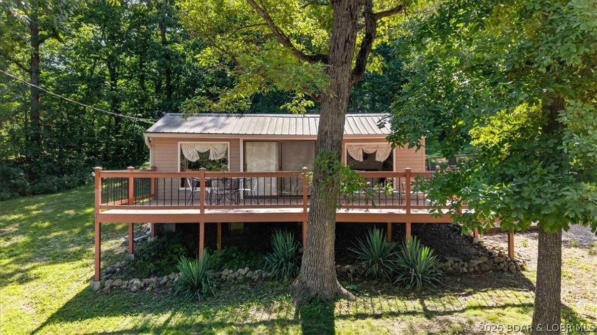 Lake life doesn’t have to come with a huge price tag or endless maintenance! This well-maintained 2-bedroom, 1-bath retreat in Lazy Acres offers an affordable opportunity to own your own place at the lake. Loved by the same family for generations, the home has been thoughtfully expanded over the years while preserving the warmth and charm that has welcomed family and friends for decades. Inside, the bright, open living space is filled with natural light and flows seamlessly into the spacious kitchen and dining area, making it easy to gather after a day on the water. Step outside to the expansive deck overlooking the lake—perfect for morning coffee, evening dinners, or simply relaxing in the shade of the mature trees. Situated on three lots, the 30x30 detached three-car garage, built in 2012, offers plenty of room for storage and workshop space! Plus, just across the road, the subdivision swim dock offers easy access for swimming and fishing, while the nearby community boat ramp makes launching a breeze. With no HOA dues and high speed internet available, this is the kind of lake place that creates lasting memories.