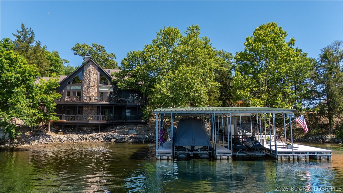EXTENSIVE, EXPENSIVE UPGRADES & EXPANSIVE VIEW! This 7 bedroom, 5 bath home has 245 ft of shoreline & no steps to the dock. In 2024 Diamond Kote siding & trim, full roof, Andersen windows & doors, skylights, gutters w/ gutter-guards, propane generator, decks w/ aluminum rails & stairs were all installed. Inside you'll notice vaulted wood ceilings, wood beams and a stone fireplace w/ new gas insert (2024) on the main level. Kitchen has a new island, Quartz counters & stone backsplash (2024). All of the carpeting has been replaced (2024) including the main en suite. The main bath has new dual sinks w/ Quartz and new shower with double shower-heads and a rain shower-head (2024).Completing the main level are an office, 2nd full bath, bedroom, laundry and pantry. Upstairs you'll find a loft,  two additional bedrooms, full bath & bunk-room en suite. Downstairs is the family room, fifth full bath and two more bedrooms. Outdoor living is easy with the lakeside stone paver patio with firepit (2025) or ~5 year old fully equipped concrete dock. 2 HVAC units were installed in 2023. Complete list of upgrades is attached. Parking is plentiful (10+ cars) and nightly rentals are allowed!