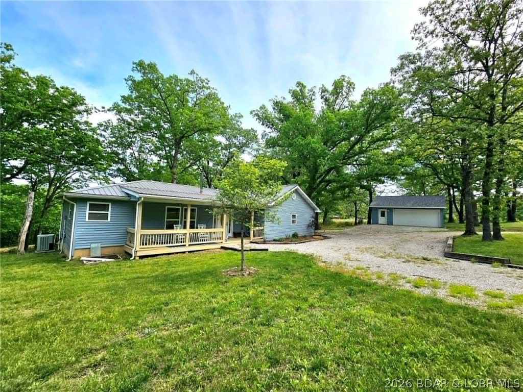 Enjoy instant equity with this country home, priced below appraised value and nestled on a peaceful 3-acre lot. This well-maintained property offers true one-level living with 3 bedrooms, 2 full baths, and an open-concept kitchen, dining, and living area—perfect for everyday living and entertaining. The kitchen features slate flooring and includes all appliances, with a refrigerator less than 6 mo old. Major updates add value and peace of mind, including a brand-new washer, a 2.5-yr-old dryer, hot water heater (1.5 years), and water softener (1 year). The spacious living room boasts vaulted ceilings with beautiful wood beams and flows seamlessly from the kitchen. The oversized primary suite includes a private en-suite bath. Take in the serene surroundings from inside the home or relax on the large deck overlooking a stocked pond and wooded acreage—perfect for enjoying abundant wildlife and nature. Situated just off a blacktop road, this secluded property offers both privacy and convenience. Additional features include a detached 2-car garage (only 2 yrs old) with electricity, a 3-stall pole barn located across the road, and a whole-home Generac propane generator for added security.