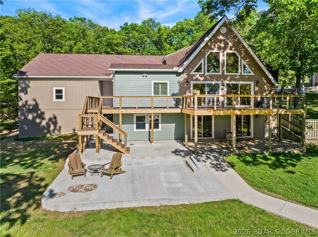 EXTREMELY MOTIVATED SELLER. Nearly flat lakefront yard, acreage, substantial garage/shop space, and no HOA or restrictions. With approx. 5,415 sqft, 5 beds, 4 baths, 3.39 acres, approx. 100 ft of lakefront, a large attached garage, and an approx. 2,326 sq ft detached shop, this property is well-suited for buyers needing room for vehicles, lake toys, equipment, business use, hobbies, guests, or multi-purpose living. The home offers open main-level living leading to a new composite deck. There's also a nearly 600sqft room perfect for gym or bunk room. The massive upper primary wing includes dual vanities, tile shower, walk-in closets, and private HVAC. A separate upper level features two additional bed/bunk rooms with walk-in closets. Even more living space in walk-out with a bed, a bath, a storm/safe room, and a rough-in for a future wet bar. An impressive & efficient masterpiece with extensive insulation, 400amp underground, 5 HVAC systems, private well, Gravois sewer, newer mechanicals, dock, and quick access to lakefront destinations make this a highly livable and VRBO-able, Lake of the Ozarks property. Check out the feature sheet to see all that this property has to offer.