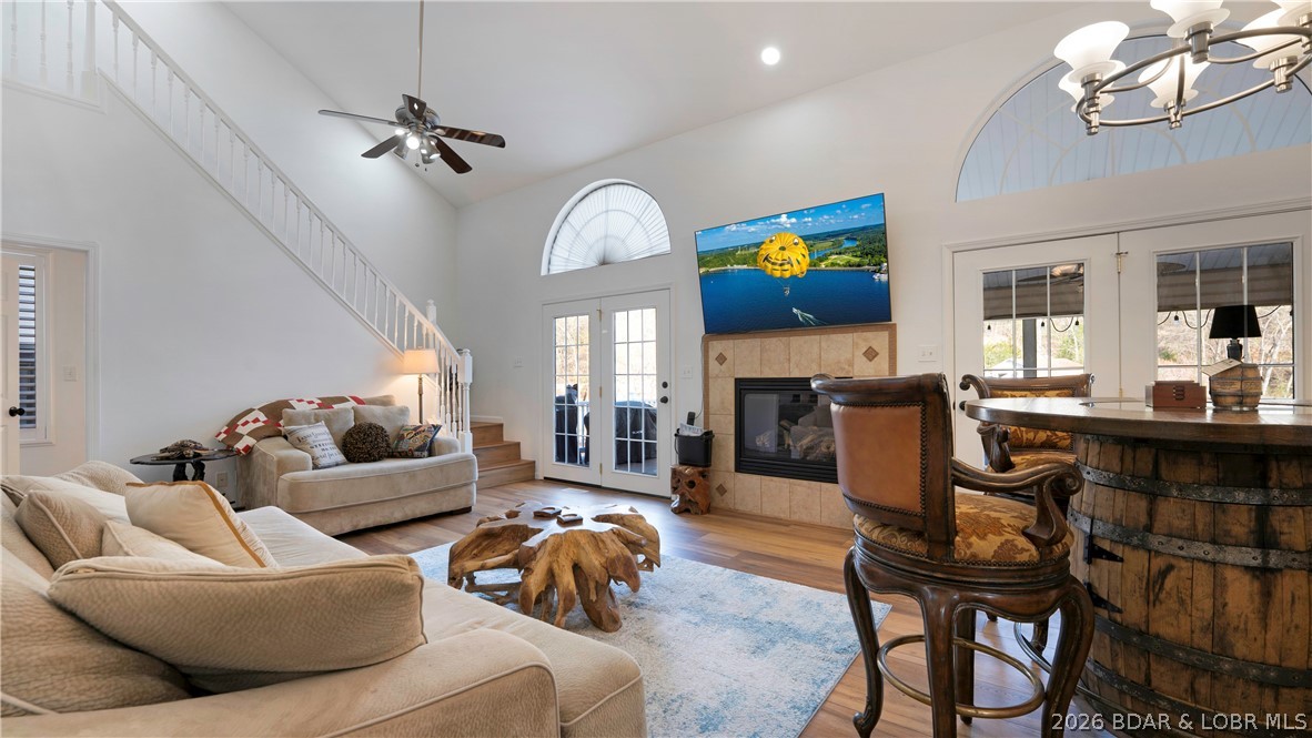 Welcome to easy lake living with this 5 bedroom, 3.5 bath home tucked inside a calm, protected deep water cove with a setting that offers a peaceful easy feeling and convenient access to the lake. This cove is perfect for fishing, kayaking, or paddleboarding, and your upper dock deck is the perfect spot for fun summer days with friends. The main level offers a rare single car garage with owners suite and open concept living kitchen and dining. The fireplace splits access to both a covered screened porch perfect for dining and an uncovered area for open air and grilling. The upper level features 2 spacious bedrooms with jack and jill bath. The lower level great room is perfect for movie or game night with 2 additional bedrooms and full bath and laundry. Easy access to lower level covered deck and minimal steps to your private oasis dock. The focal point of this lake retreat is the rooftop deck with views all the way to the main channel and enough room for everyone. 12x32 slip with hoist with 3 covered PWC slips including a double PWC hoist providing room for all of your lake toys. Nightly rentals allowed making this the perfect investment opportunity or vacation get-away or BOTH!