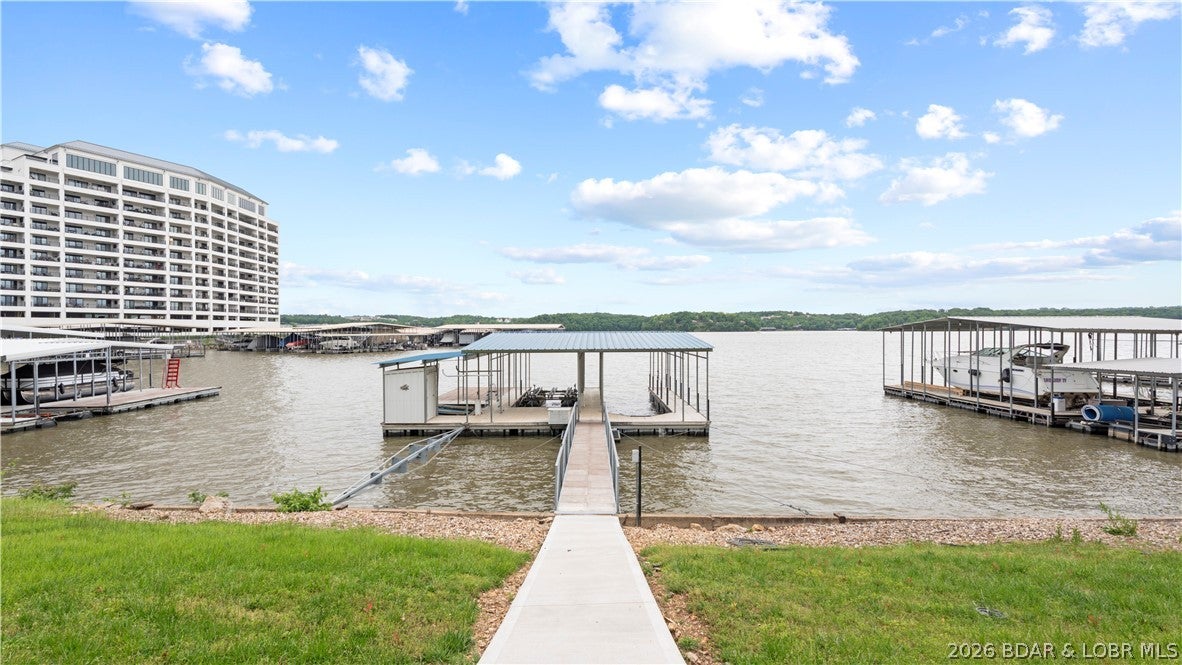 Experience unparalleled lakefront living where every detail enhances your connection to the water. This stunning 3-bed, 2.5 bath home offers breathtaking panoramic lake views from every angle. The spacious inviting interior features a sophisticated open concept, a cozy fireplace and a separate wet bar, ensuring drinks are always at hand. Enjoy the dedicated four-seasons room for bright year-round picturesque beauty. Retreat to the luxurious primary ensuite offering a haven of comfort and space with a walk-in shower and "his & hers" closets providing ample storage. Outside, a massive open deck stretches out offering generous space for al fresco dining or soaking in the beauty, dusk to dawn. A moderate slope leads to your private 3-well dock, including an 11 x 40 ft slip, storage shed for all your lake gear, and the convenient path ensures effortless access to the water. This exceptional 100 feet of prime lakefront property is completed by a 2-car garage offering ample space for vehicles, a golf cart, and extra storage. Don't miss your extraordinary chance to own this slice of paradise, where luxury meets leisure and every day promises a vacation.