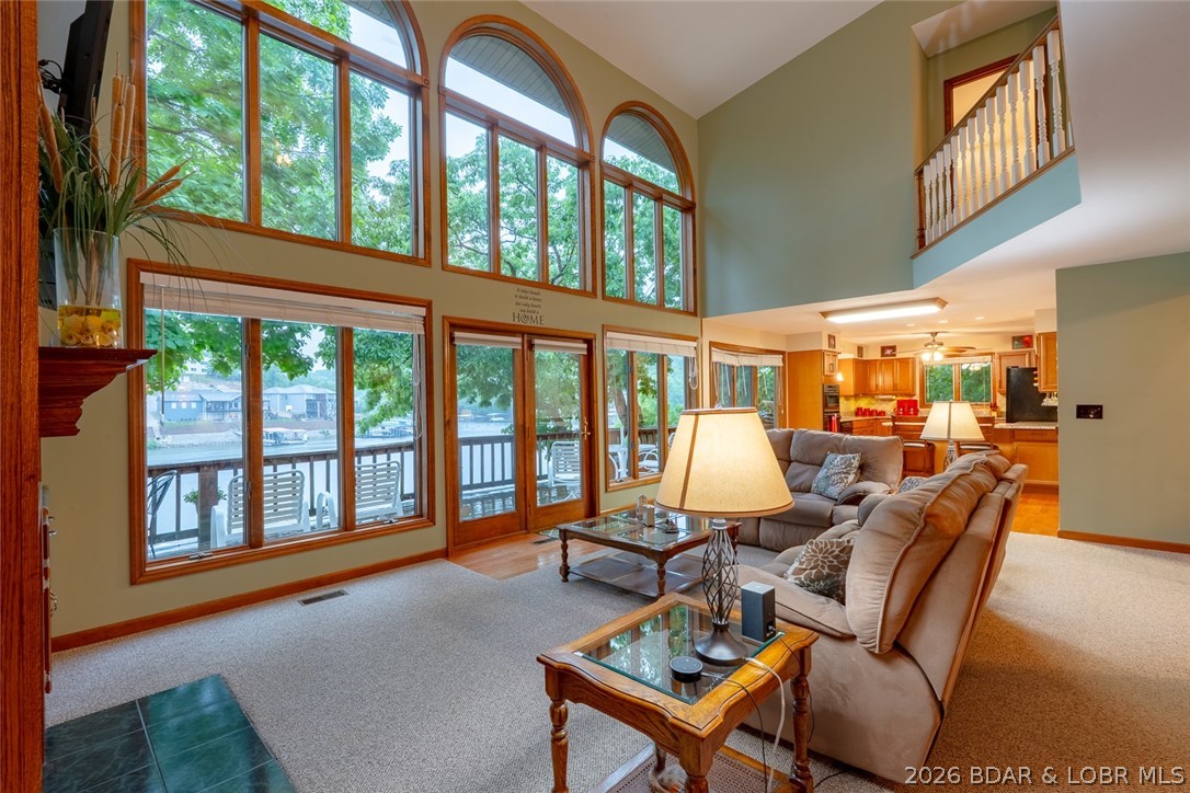 Welcome to lakefront luxury in coveted Bogue Bay at the 4MM of the Gravois Arm. Hitting the market for the very first time, this stunning furnished 5 bedroom, 5 bath retreat offers the perfect blend of elegance, comfort, and investment potential. The main level showcases soaring vaulted ceilings and a dramatic wall of windows that flood the home with natural light while framing breathtaking lake views. The open concept design features a spacious family room, kitchen with breakfast nook, formal dining area, laundry room, and an oversized primary suite complete with a spa-like ensuite featuring a walk-in shower,  an oversized air bath tub and a walk-in closet. Upstairs, the loft-inspired level overlooks the great room below and offers an additional family room, 3 guest bedrooms, a full bath with dual vanities, and a half bath. The walkout lower level features another family room, guest bedroom, full bath, and utility room. Just steps from the lower deck sits the two-well dock in a sought-after cove setting. Comfortably sleeping 14+ guests, this home is ideal as a luxury full-time residence, weekend retreat, or vacation rental opportunity. Schedule your showing today!