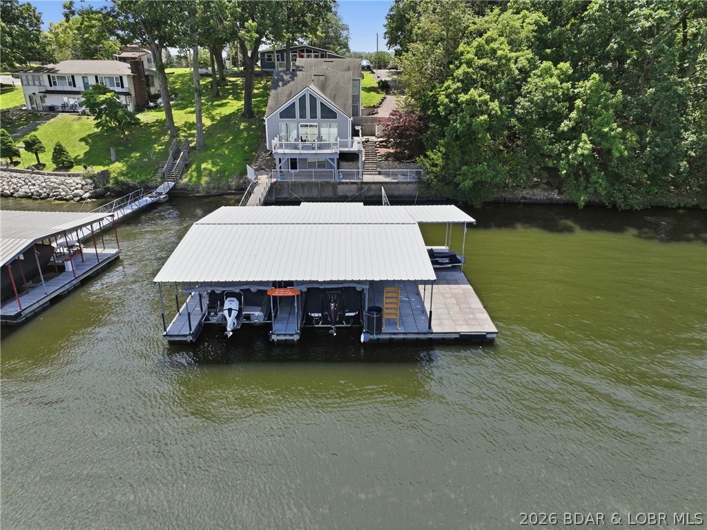 Lakefront Living Meets Investment Opportunity With This Fully Furnished 3-Bedroom, 2-Bath Home Offering 60' of Protected Cove Frontage and Expansive Main Channel Views. Inside, You'll Find Soaring Tongue-and-Groove Vaulted Ceilings And a Dramatic Wall of Floor-to-Ceiling Windows That Fill The Home With Natural Light. On The Main Level of the Home, You'll Find a Spacious Layout Including The Living Area, Dining Room, Kitchen And Primary Suite. Upstairs, You'll Find a Spacious Loft, Two Additional Bedrooms And a Convenient Jack-and-Jill Bath! The Lower-Level Of The Home Provides a Second Living Space, Utility Room and Convenient Access To The Lakeside Patio and Dock! Need Extra Space? The Detached Garage Includes Two Additional Bedrooms, a Full Bath, And a Kitchenette-Perfect For Guests Or Added Rental Flexibility! The Dock Is Where The Party Happens- Massive 40x50 Dock, 2 Boat Slips (12x30, 12x24) With a Swim Platform, Roll-Up Bar Area/Storage Shed, Deep Water Year-Round and Plenty of Space to Entertain! Recent Updates Include a New HVAC System And Mini-Splits In The Upper Bedrooms! Short-Term Rentals are Allowed! Schedule Your Private Showing Today!