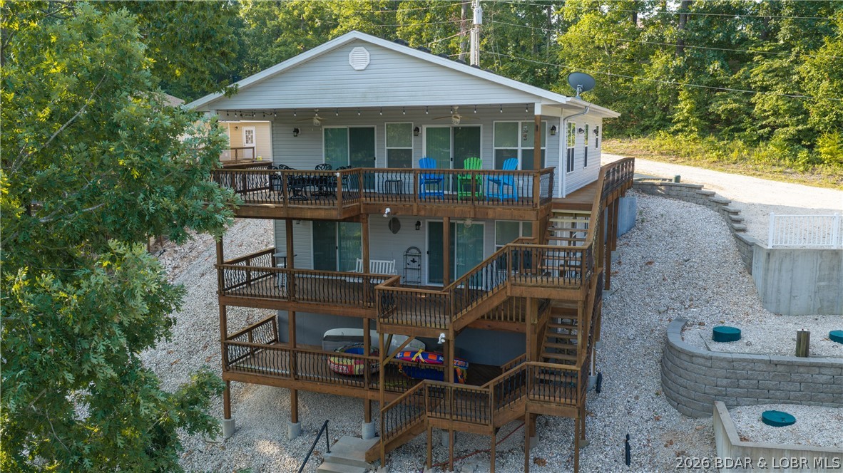 Experience the perfect blend of location & lakefront living on the coveted North Shore. Ideally situated just 4 miles from the iconic Strip & Hwy 54, this 4-bedroom, 2.5-bath waterfront retreat places you minutes from the Lake's attractions. Nestled in a peaceful, protected cove, offering picturesque views & ideal swimming conditions, creating unforgettable days. Relax on the expansive swim platform or entertain with your own lake bar while enjoying the tranquil cove setting. Inside, the meticulously maintained residence showcases updated HVAC, luxury vinyl plank flooring, new carpet & an oversized two-car garage. The thoughtfully designed main level features open-concept living with an expansive kitchen highlighted by a large center island, dual pantries, spacious living area with fireplace & a large primary suite complete with a walk-in shower & closet. An impressive upper-level bump-out covered deck extends the living space outdoors, providing entertaining space with peaceful lake views. The walkout lower level offers two oversized bedrooms, a versatile fourth bedroom or family room & a lakeside deck. Delivering the ultimate Lake lifestyle where every day feels like a vacation.
