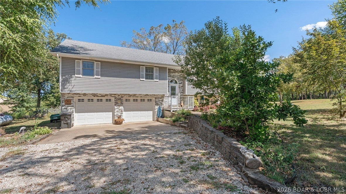Welcome home to this spacious 3-bedroom, 2.5-bath property, beautifully situated on a 3+ acre lot outside city limits. Located just off the highway, it offers peaceful country living with convenient access to nearby amenities. Inside, vaulted ceilings and an open-concept layout create a bright, inviting atmosphere. Large bright kitchen has spacious counter tops, custom cabinets with slide out drawers, and stainless steel appliances. The primary bedroom includes an ensuite bathroom, while the spacious lower-level family room provides plenty of room for entertaining, relaxing, or creating a play area for the kids. Recent exterior upgrades include new siding, gutters, double insulation, and garage doors. The oversized garage offers ample space for vehicles, storage, hobbies, or a workshop. Outside, enjoy the walkout patio, nicely landscaped yard, and scenic rows of walnut trees that add natural beauty and privacy. With generous indoor and outdoor living space, thoughtful updates, and room to grow, this property is a wonderful place for a growing family to call home.