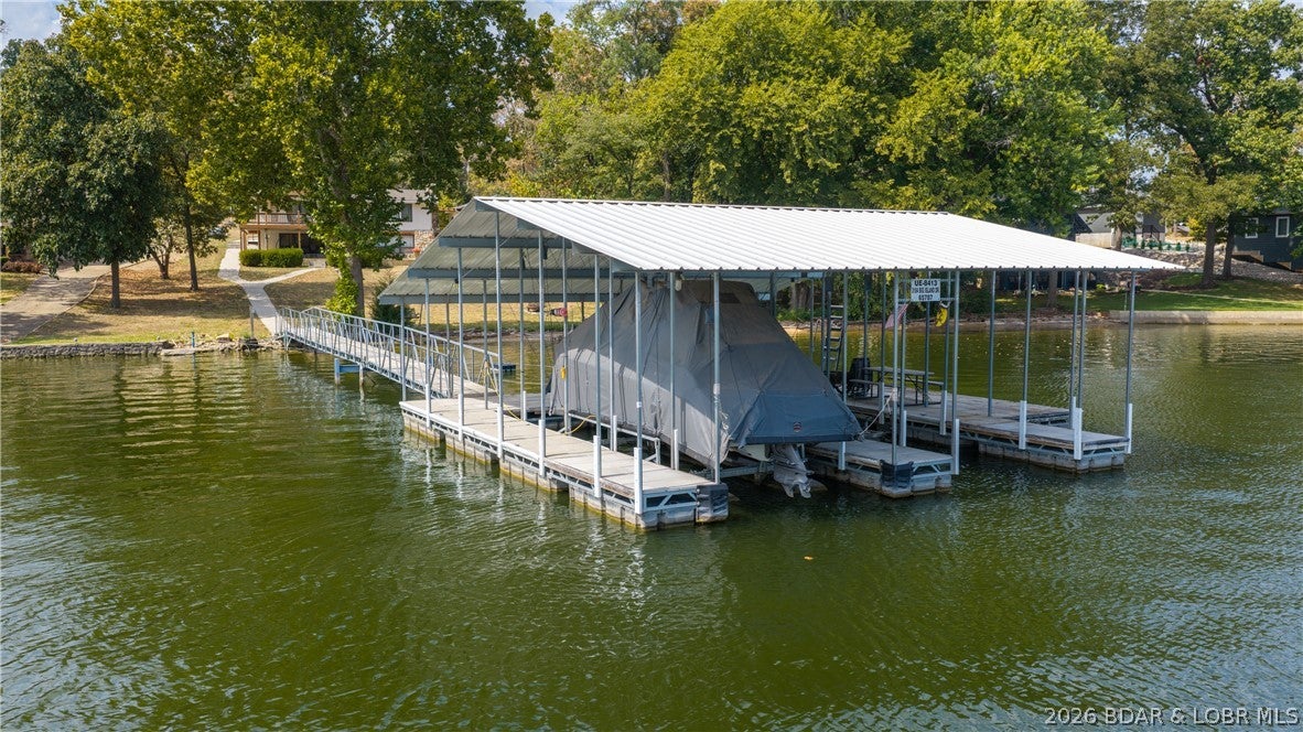 LAKEFRONT HOME WITH LEVEL YARD & SANDY BEACH!  Come see this 4 bedroom, 2 1/2bath, 3 car extended garage, 2 well concrete dock lakefront home. Located in the desired Big Island neighborhood, this home has 180 feet of lakefront. You'll appreciate main level living and only 4 steps to the dock. On the open concept main floor you'll enjoy expansive lake views, newer light & plumbing fixtures, vaulted wood ceilings, carpeting (2022) and remodeled kitchen with custom cabinets, coffee bar with prep sink & quartz countertops. The roomy primary bedroom has a walk-in closet, bath with walk-in shower and full sized washer & dryer. A half bath, access to the partially covered deck and second bedroom complete the first floor. On the lower level you'll enjoy the family room with gas fireplace and newer carpeting (2024), two additional bedrooms, laundry room with second dryer (and washer hook-up), access to lower level patio and full hallway bath. This home is almost completely handicap accessible. The extended three car garage is the man cave you've been looking for. The roofs on the house and garage were new in 2024!  Nightly rentals are allowed. Come check out this unique opportunity today.