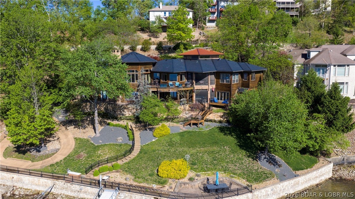 Lodge-style lakefront retreat sitting on over 1 acre with an impressive 276 feet of lakefront. Situated in Four Seasons, this 6 bedroom home features 7 bathrooms with every bedroom but one designed as a private ensuite. The cove location is the perfect blend of water while still capturing wide-open views, with plenty of room to add a pool if desired. Originally built in 1993 and completely renovated down to the studs in 2009, the home showcases hand-scraped hickory floors, a new DaVinci composite slate tile roof, Italian copper gutters, real timber structural posts, rough-cut timber decking, commercial grade water softener system, new Bosch double oven, and ice machines on both levels. The hot tub room overlooking the lake is a must see. Inside also includes an office and private theatre room, while the home comes fully furnished, so you can move right in and start enjoying the lake. The large dock features new concrete tiles along with a 15x48 slip, 12x36 slip, and dual PWC slips to accommodate all your lake needs. A 3-car garage and ample additional parking complete the package. This is a rare opportunity to own a true lakefront estate with acreage and extensive lakefrontage.