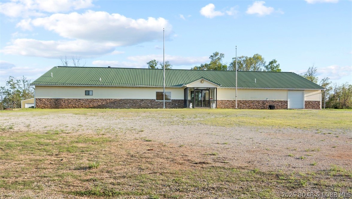 This versatile commercial property offers an exceptional opportunity with approximately 15 + acres of level, usable land—ideal for a wide range of business or development possibilities. Previously operated as a Lions Club, the building is well-equipped and thoughtfully laid out to accommodate both large gatherings and functional workspace needs. Inside, you’ll find a spacious open floor plan perfect for events, retail, or conversion to suit your business vision. Includes a fully equipped commercial kitchen, Men’s and women’s restroom facilities are already in place, along with three office areas, and laundry facilities. Additionally, there is an attached storage/garage area as well as a detached exterior garage, offering ample room for equipment, inventory, or vehicles. The primarily level acreage provides excellent potential for expansion, including storage buildings. Conveniently located .5 miles off Hwy 5, property offers both accessibility and visibility. Whether you’re looking to establish an event venue, business headquarters, storage facility, or redevelopment project, this property delivers space, functionality and opportunity for growth!