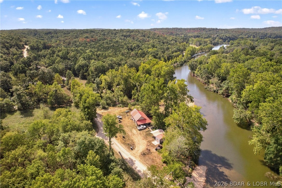 Discover your own private nature retreat! One of the most moving pieces of real estate that you will ever see!  This charming cabin is nestled on a beautiful 1-acre property along Indian Creek, offering gorgeous water and wooded views and a peaceful setting surrounded by nature. An Artesian well is on the property and a permit is in place to haul gravel from the creek! Adding even more value and privacy, the property includes an additional approximately 4-acre tract, which will need to be surveyed, giving you roughly 5 acres to enjoy. Whether you’re looking for a weekend getaway, hunting retreat, or a place to escape the hustle and bustle, this unique property offers endless possibilities. A rare opportunity to own a true nature hideaway with water frontage and plenty of room to explore, relax, kayak, swim and enjoy the great outdoors.  Additional 4 Tracts of wooded Indian Creek Property is available to purchase.  2nd bedroom is in the loft.