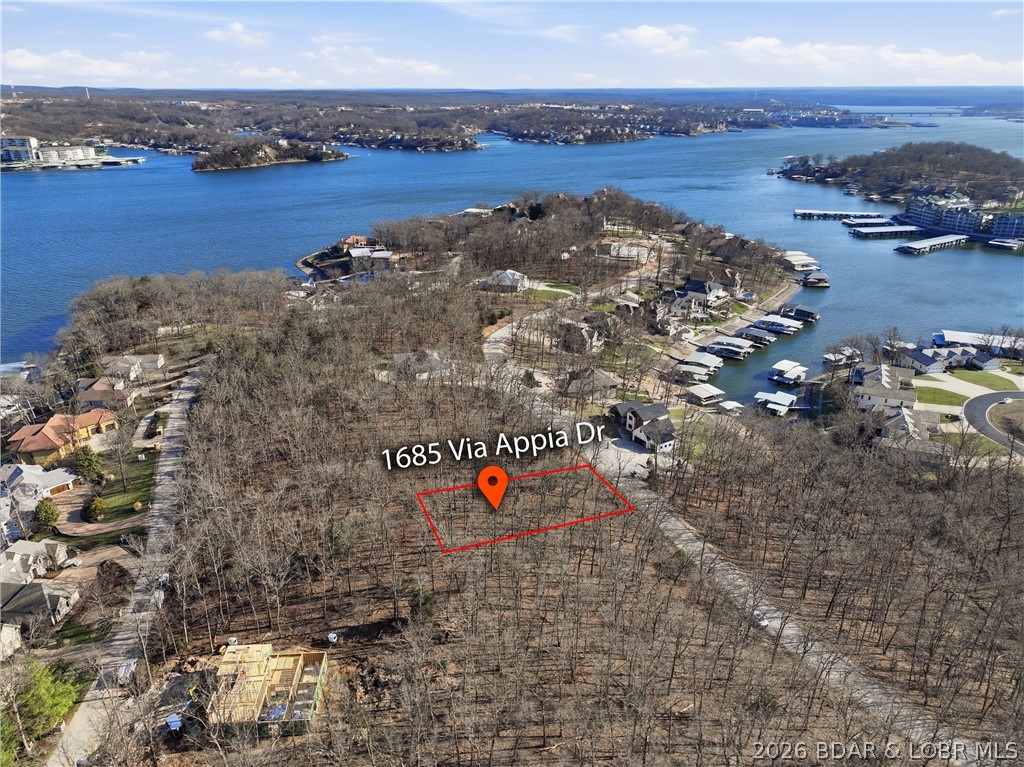 Exceptional vacant lot with beautiful direct water views located in the prestigious community of Porto Cima! This property offers the perfect setting to build your custom dream home while enjoying a peaceful view of the lake. A short golf cart ride takes you to the Yacht Club and Marina, and renowned Jack Nicklaus Signature Design Golf Course - The Club at Porto Cima - widely regarded as one of Missouri’s premier golf courses and the only private course at the lake.  Enjoy a convenient location 5 minutes from boat ramps, marinas, shopping, dining and more in this thriving community near the 16MM bridge. Four Seasons amenities include 5 Boat Ramps, 4 outdoor pools, indoor Aquatic Center, Tennis, Fitness Center, Pickleball, Basketball, Boat Storage, Campground, Playgrounds, and 3 interior lakes.  Experience the tranquility of water, elegant surroundings, and the exceptional lifestyle that comes with living in one of the lake’s most desirable communities.