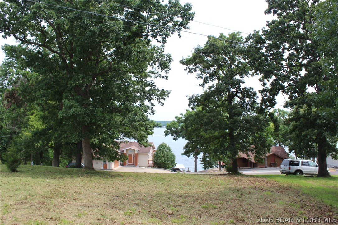 Welcome to your new lakeview homesite! This exceptional 2+ acre parcel overlooks the 8MM of the main channel at Lake of the Ozarks, offering breathtaking views without the premium price of lakefront ownership. Located on paved roads all the way to the property—no gravel to navigate—this tract is ready for your dream home. Electric service is already on site, and Gravois Sewer District lines run along the road frontage, helping reduce future building costs. The gently rolling terrain provides multiple ideal building sites, while the wooded rear of the property offers privacy, abundant wildlife, and plenty of space for a detached garage, workshop, walking trails, or other outdoor amenities. Large acreage parcels in the highly desirable O Road area close to shopping and entertainment are becoming increasingly difficult to find. Whether you're ready to build now or invest for the future, this versatile property is an outstanding opportunity. Don't wait—properties like this don't stay available for long!