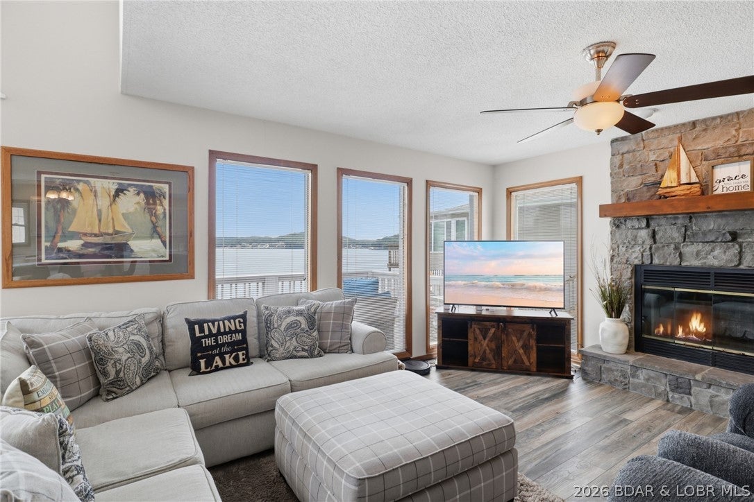 INVESTORS TAKE NOTE! DEEP WATER COVE! LARGE 3-WELL DOCK! Wake up to breathtaking easterly views from this sell maintained 3-bed, 3-bath lakefront home, perfectly positioned in a protected cove at the 5 Mile Marker. The open-concept main level takes full advantage of the incredible setting w/ soaring vaulted ceilings, a wall of lakeside windows framing panoramic water views, a cozy wood-burning fireplace, wet bar, designed for entertaining. The private upper-level primary suite offers a peaceful retreat complete with its own lakeside balcony, while the walkout lower level features a spacious family room ideal for guest. Multiple decks provide plenty of room to enjoy morning coffee, evening grilling, and the ever-changing views of the lake. At the water, the included 3-well dock w/10x28 slips plus a PWC lift, offering exceptional space for boating and lake recreation. With its protected cove setting, expansive main channel views, versatile layout, and impressive dock setup, this property offers an outstanding opportunity at Lake of the Ozarks. New HVAC. This lovely row of houses is primarily vacation rentals so proven popularity with vacationers! SEE Rental Projections attached.