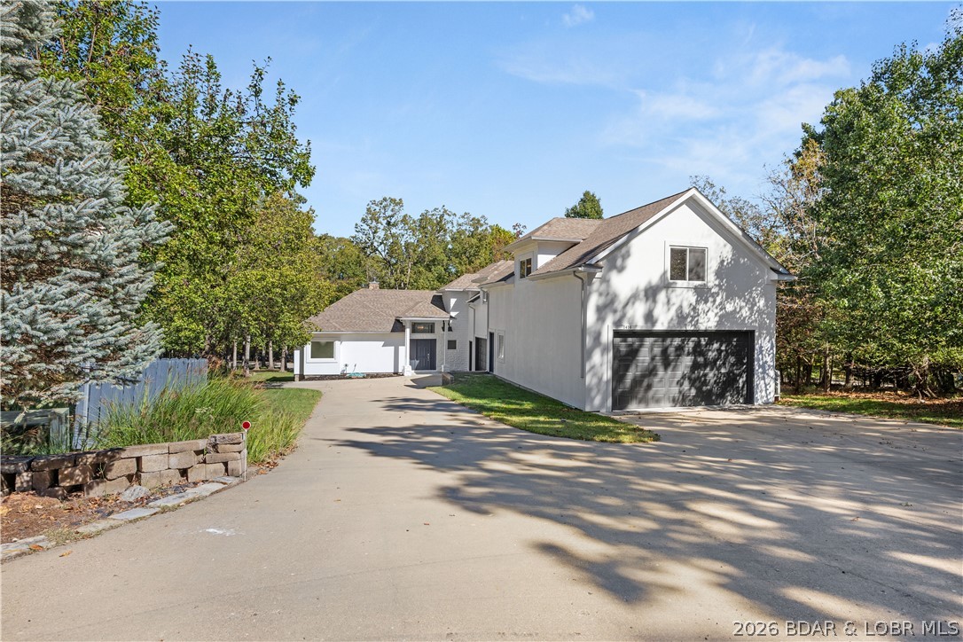 Experience unparalleled refinement in this exquisitely remodeled two-story estate within the prestigious Porto Cima community of Sunrise Beach, MO. Spanning over 3,800 square feet of luxurious living space, this four-bedroom, 3.5-bath masterpiece reflects a stunning six-figure renovation where absolutely no expense was spared. An immaculate open floor plan seamlessly blends sophisticated comfort with abundant natural light, showcasing premier finishes and elite modern upgrades throughout. The main level offers effortless living, anchored by a magnificent primary suite, an elegant living area with a cozy wood-burning fireplace, and a gourmet walk-in pantry. Ascend to the upper level to discover a charming den alongside two spacious bedrooms sharing a classic Jack-and-Jill bath. A spectacular crown jewel of this estate is the massive 1,500-square-foot, 6-car tandem garage—a dream for connoisseurs or workshop enthusiasts—paired with separate, rustic apartment-style guest quarters ideal for premier hosting or rental income. Nestled on a quiet cul-de-sac, the property boasts flat parking, a grand open deck, and seasonal lake views. Live the ultimate statement of luxury lake living.