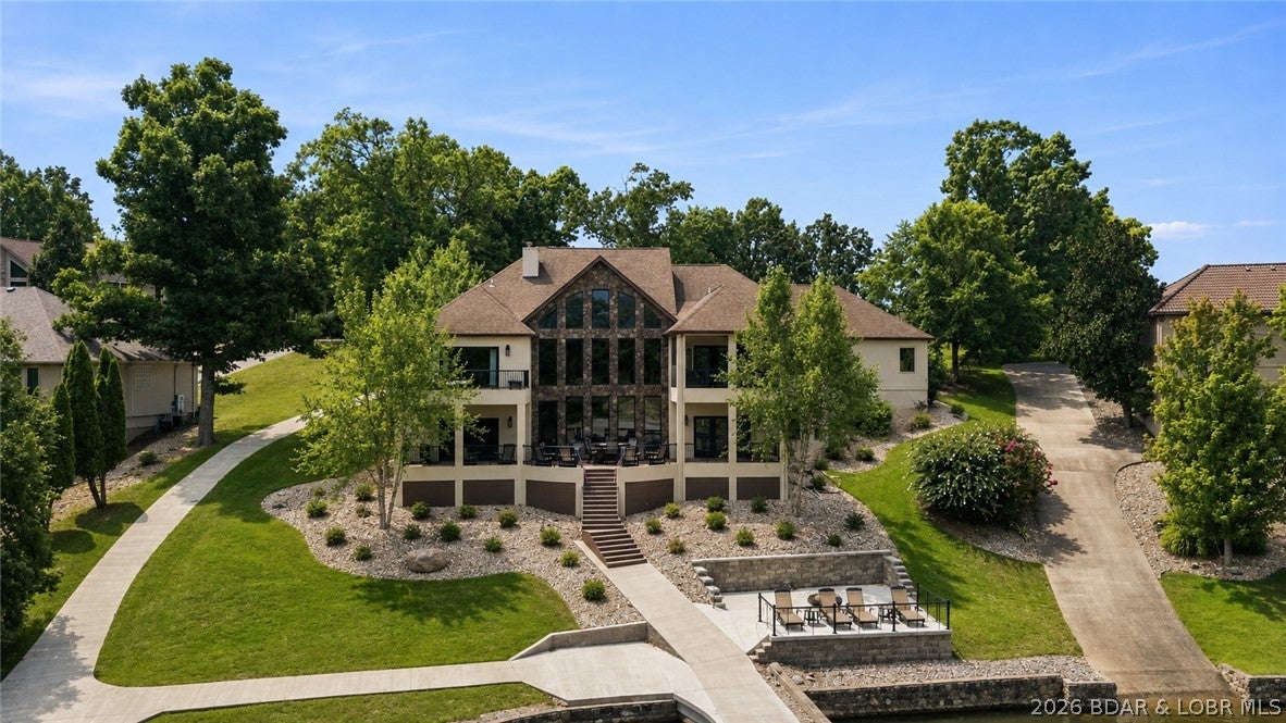 Experience the perfect blend of luxury, privacy, and convenience in this exceptional lakefront retreat located in one of Osage Beach's most sought-after gated communities. Nestled at the end of a long, flat driveway, this remarkable property offers a true estate-like presence-an incredibly rare find at Lake of the Ozarks. Recently updated with stylish finishes and designed for comfortable lake living, this expansive home features 5 spacious bedrooms and generous living areas that provide plenty of room for family and guests. Whether you're looking for a full-time residence or the ultimate lakefront getaway, this home offers the ideal balance of elegance and functionality. Step outside to discover multiple outdoor entertaining spaces, perfect for hosting family and friends, enjoying peaceful mornings with coffee, or unwinding while taking in the beautiful lake views. One of the home's most desirable features is its effortless access to the water. With a nearly level approach and minimal stairs leading to your private dock, and new martini decks! Enjoying life on the lake has never been easier.