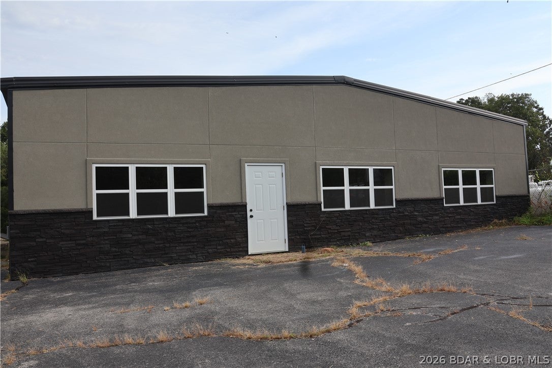 Prime Commercial Opportunity High visibility, excellent accessibility, and endless possibilities! Located just 1 mile from the Camdenton Square along highly traveled Business Route 5, this versatile 4,000± sq. ft. commercial property offers outstanding potential for an owner-user or investor. The property has received numerous upgrades, including new windows, doors, paint, flooring, and improvements to the heating and air conditioning serving the spacious shop area. The flexible layout provides the opportunity to operate one larger business or potentially subdivide the building into multiple spaces, creating additional leasing and investment opportunities. With its central Camdenton location and proximity to Lake of the Ozarks, this property could accommodate a wide variety of commercial uses. Potential possibilities include a CrossFit facility, fitness center, retail operation, smoke shop, boat or marine service business, automotive-related business, contractor headquarters, warehouse, showroom, or other service-based operation. Whether you’re looking for a highly visible location to grow your own business or an investment property with potential for multiple tenants.