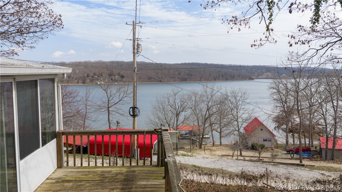 Discover affordable lake living at its best! Nestled in a peaceful neighborhood at the 76 MM, this 2-bedroom, 1-bath home is packed with potential and perfect for anglers, weekenders, or anyone looking to enjoy the Lake of the Ozarks lifestyle. Take in the expansive lake views from the spacious four-seasons room or launch your boat with ease from the community boat ramp directly across the street. Multiple outbuildings and a large detached garage provide ample space for boats, fishing gear, tools, and lake toys. Just a few doors away, you'll find a convenient bait shop, making early morning fishing trips a breeze. Residents also enjoy access to a lakefront community pavilion, ideal for family gatherings and celebrations. This home is a true diamond in the rough, offering the chance to add your personal touch and build equity. Whether you're searching for a full-time residence, weekend getaway, or investment opportunity, this property delivers exceptional value. Being sold AS-IS.