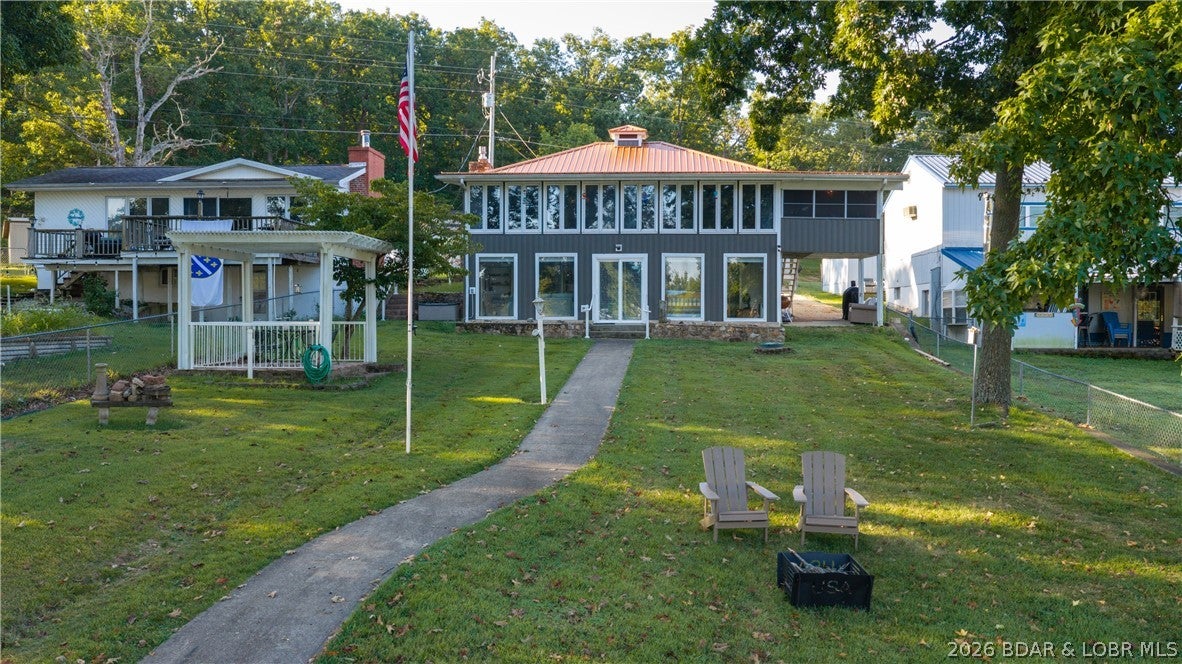 Welcome to your ideal lakefront retreat on a flat lot in Mill Creek Cove! 3- bedrooms and 2- bathrooms tucked into a calm cove off Mill Creek Cove.  Paddle board, swim, kayak and float without having to "ride the waves" in this deep wide cove. Close to your favorite places like Jolly Rogers and Lake Burger; there's always something fun to do. Ride just 3 miles North to popular Coconuts and beautiful Indian Creek Cove. Head the other direction to Tap N Grill, H. Toads, Camden on the Lake and Shady Gators.  A LARGE 3 well dock with 2 PWC lifts and an attached swim platform, perfect for dock entertaining!  Have a lot of toys?  This is your house!  There's a three car detached garage (24x36) with the third bay finished out as a workshop. Whether you'[re looking for a a vacation home or an investment opportunity, this home is ready to go!  Call you real estate professional today!