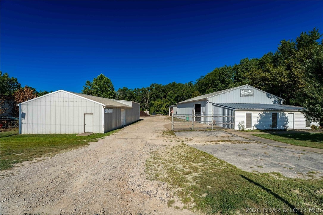 Excellent commercial lease opportunity located just off Highway 42 on the edge of Osage Beach. This property offers two buildings totaling approximately 9,000 sq. ft., including approximately 1,000 sq. ft. of office space. With five bays between the two buildings, 18-foot clear ceiling heights, and 14-foot roll-up doors, the space can accommodate a wide variety of commercial, service, storage, or light industrial uses. The office area features three mini-split systems for heating and cooling, along with two bathrooms, providing a comfortable and functional workspace separate from the shop areas. The property also includes 12 dedicated parking spaces for employees, customers, or company vehicles. Convenient access to Highway 42 provides an ideal location for businesses needing easy access throughout Osage Beach and the surrounding Lake of the Ozarks area. With generous square footage, multiple bays, high ceilings, and dedicated office space, this property offers the flexibility to fit a variety of business needs.Equipped with 120/240V single-phase electrical service, perfectly suited for retail, professional office space, or light commercial use.