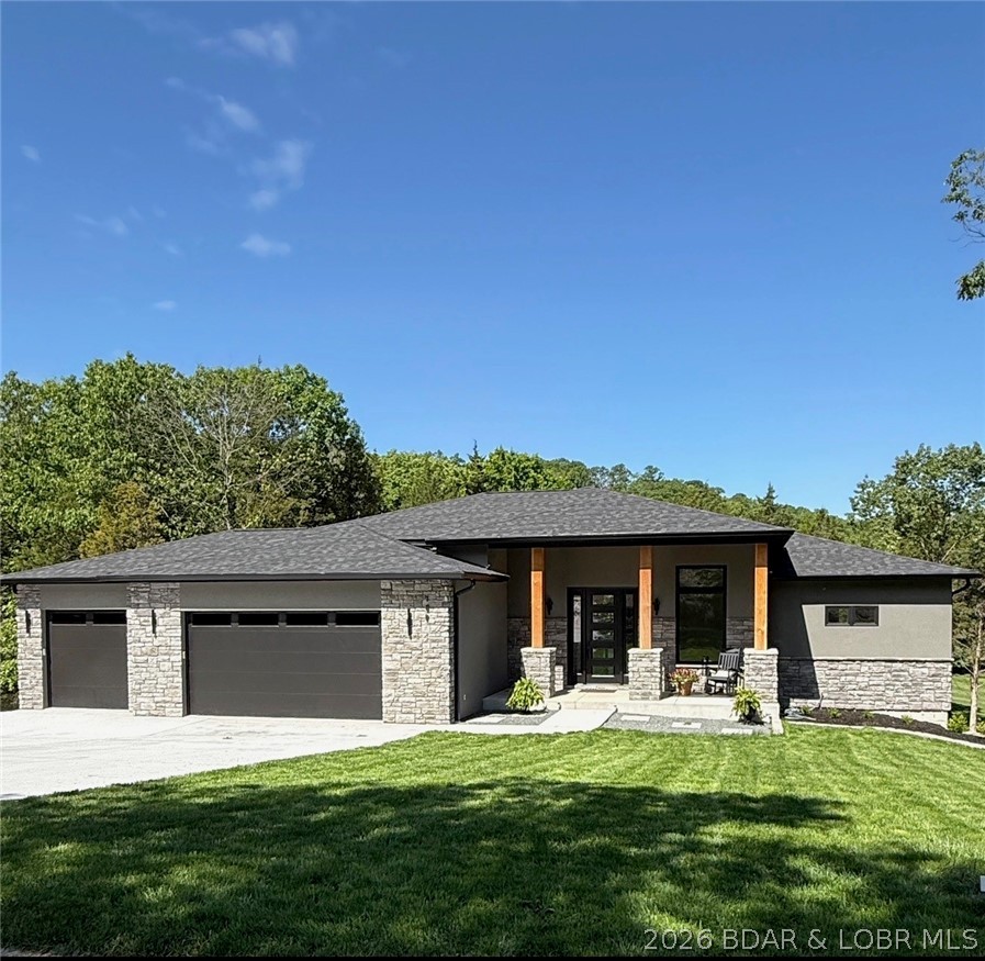 Brand-new construction in the highly sought-after Old Kinderhook community, perfectly positioned on the 3rd hole of the golf course. Designed with quality craftsmanship and thoughtful upgrades throughout, this home offers a level driveway, oversized 3-car garage, and an additional lower-level garage ideal for a golf cart, workshop, storage, or future pool house. The open main-level floor plan features a stunning great room with soaring ceilings and an impressive fireplace, a beautifully designed kitchen with custom cabinetry and upgraded appliances, plus a spacious dining area with easy access to the large deck for entertaining and grilling. The main level also includes two suites, a dedicated office or possible fifth bedroom, full laundry room, and half bath. The walkout lower level offers a large family room with stone fireplace and plumbed wet bar area, two additional bedroom suites, generous storage, and utility space. Concrete patios lead to the oversized golf cart garage/workshop. Large level yard ideal for a future pool, fire pit, and outdoor fun. Old Kinderhook amenities included. 400-amp service. Conveniently located near dining, marina access, and resort-style amenities.