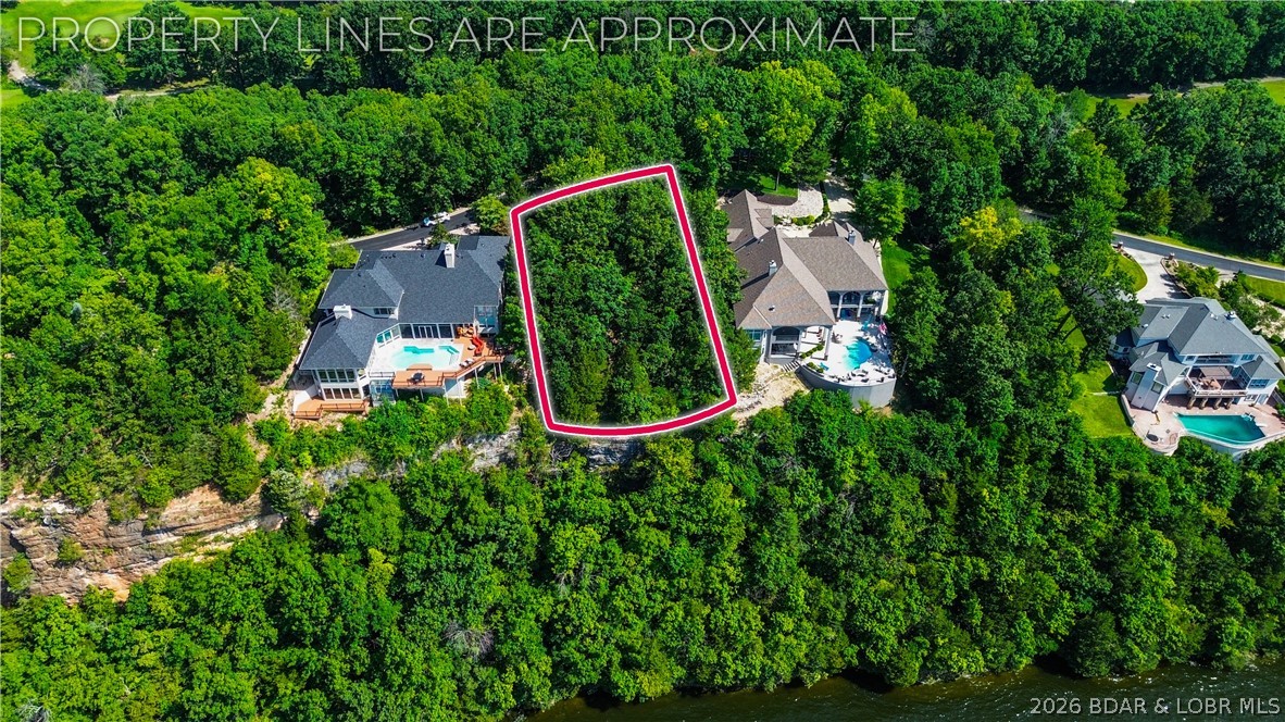 One of the last opportunities to build in prestigious Cedar Crest! This spectacular lakefront lot is located in one of Lake of the Ozarks' most exclusive gated communities, where luxury homes, manicured grounds & breathtaking views create an unmatched setting. Nearly built out, Cedar Crest rarely offers vacant lots, making this an exceptional opportunity to build your dream home among some of the area's finest residences. Offering approximately 108 ft of lake frontage and nearly a half-acre, the homesite features a level building area with dramatic bluff-top views overlooking the lake. The panoramic vistas are simply incredible and provide the perfect backdrop for a custom luxury home. Beyond the property itself, you'll love Cedar Crest's beautifully landscaped entrance complete with water features, flowers & meticulous grounds. Residents enjoy a community pool, tennis courts & a community dock where boat slips are often available. Located just seconds off Horseshoe Bend Parkway, you'll appreciate one of the most convenient locations at Lake of the Ozarks. If you've been waiting for the right lot in the right neighborhood, here is your chance to build in beautiful Cedar Crest!