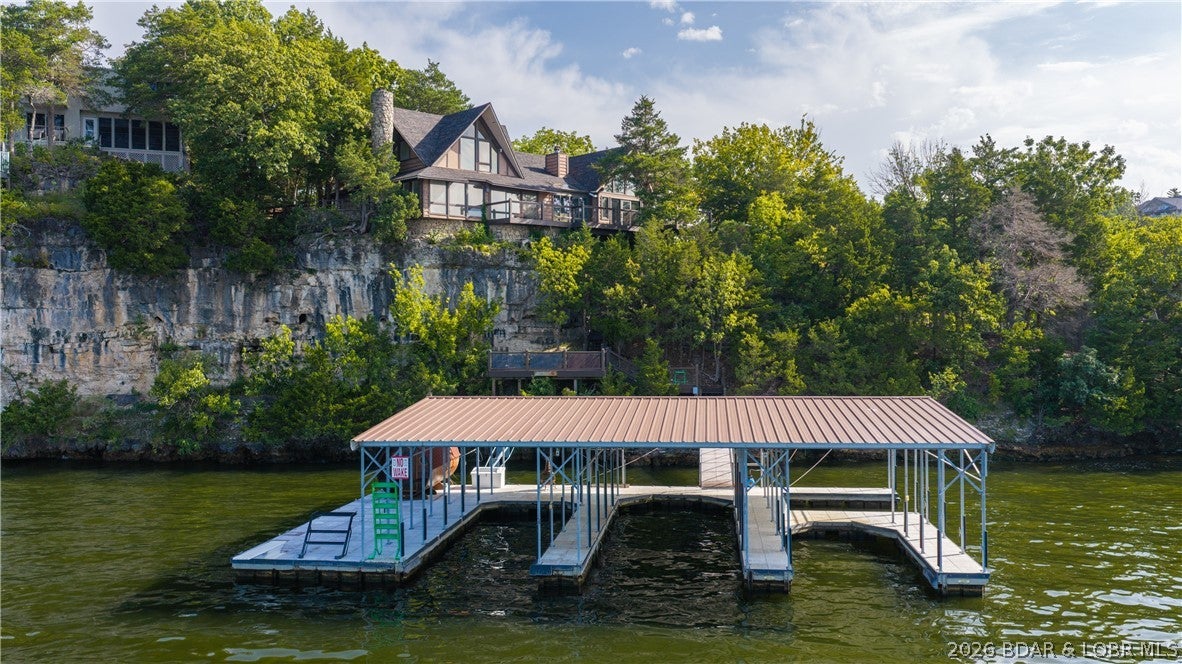 Experience lakefront living at its finest just seconds from Margaritaville. Nestled on a quiet cul-de-sac at the coveted first point of Tan-Tar-A Estates, this exceptional turnkey home offers breathtaking channel views, stunning landscaping, and brand-new decks designed to maximize the scenery. The private dock, complete with an imported sauna-which makes it ideal. Inside, you'll find a beautifully updated interior featuring custom cabinetry, granite countertops, premium Miele, Dacor, and Fisher & Paykel appliances, an ice maker, wet bar, and two fireplaces—including a see-through fireplace in the luxurious primary suite. The spa-inspired primary bath showcases exquisite tilework, a walk-in glass shower, soaking tub, and lake views. This 3 bedroom (3rd bedroom non conforming) has vaulted ceilings, expansive living spaces, & walls of windows create an inviting retreat. Outside, enjoy multiple decks, a stone patio, and a serene Japanese garden. Rare for the neighborhood, the property includes an oversized 2-car garage plus a golf cart bay. This one-of-a-kind home blends elegance, comfort, & unmatched views in one of the Lake’s most sought-after locations. Property is not for rent.