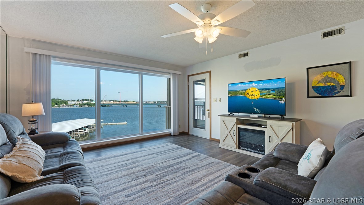 Enjoy spectacular main channel views and a front-row seat to the iconic Grand Glaize Bridge from this beautifully maintained 2-bedroom, 2-bath condo in the heart of Osage Beach. Perfectly positioned across the channel from the exciting new Oasis development, this property offers both a stunning lake setting and exceptional convenience. The interior features newer LVP flooring throughout the living and dining areas and both bedrooms, along with fresh paint and new lakeside windows that maximize the view and natural light. Offered turn-key, the condo includes furniture, décor, and kitchenware, making it ready for immediate enjoyment or rental potential. Relax on the deck overlooking the pool while taking in the panoramic lake views, or head out on the water from your included 10x30 boat slip on Dock D, located in a protected cove. The condo is just a few steps from parking in this well-maintained complex, ideally situated near shopping, dining, entertainment, healthcare, and many of the Lake's most popular waterfront destinations. Whether you're looking for a full-time residence, vacation getaway, or investment opportunity, this centrally located lakefront condo checks all the boxes.