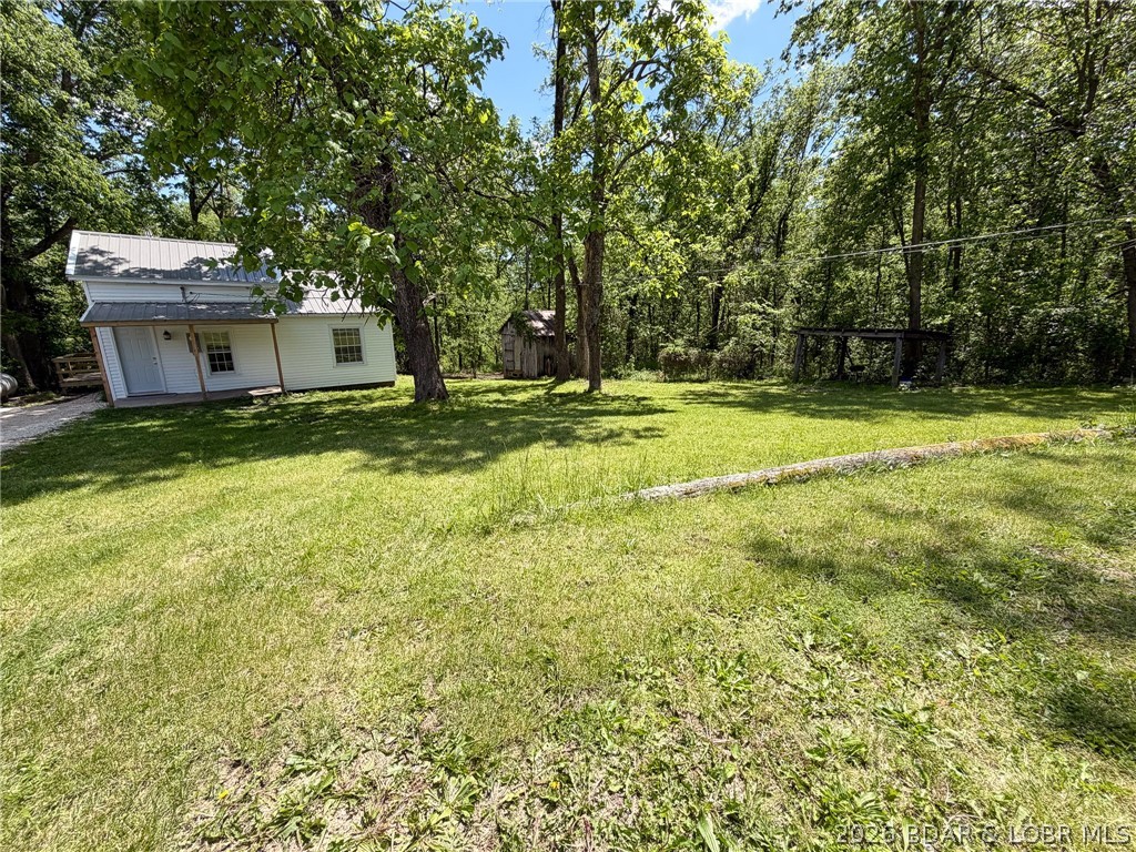 New updates! Seller recently installed two energy-efficient mini-split systems providing both heating and cooling throughout the home with NO increase in the price. This charming updated  1940's bungalow home offers timeless character with numerous improvements completed within the last year. Surrounded by mature trees and sits on a spacious lot with convenient access to town amenities, this property delivers small-town living with room to breathe. Recent updates include a new metal roof, extended front porch, new deck, new water heater, updated siding on the front and rear of the home, updated lighting fixtures, ceiling fan, refreshed ceiling, added insulation.  The welcoming porch and new deck provides an inviting outdoor space for relaxing or entertaining .  Enjoy the simplicity of Ozark living in the historical town of Iberia, near Lake of the Ozarks with endless opportunities for boating, fishing, & outdoor adventure year-round! Whether you are searching for a full-time residence, weekend getaway, investment opportunity, or cozy retreat, this updated home offers charm, affordability, and room to make it your own at an attractive price point!
