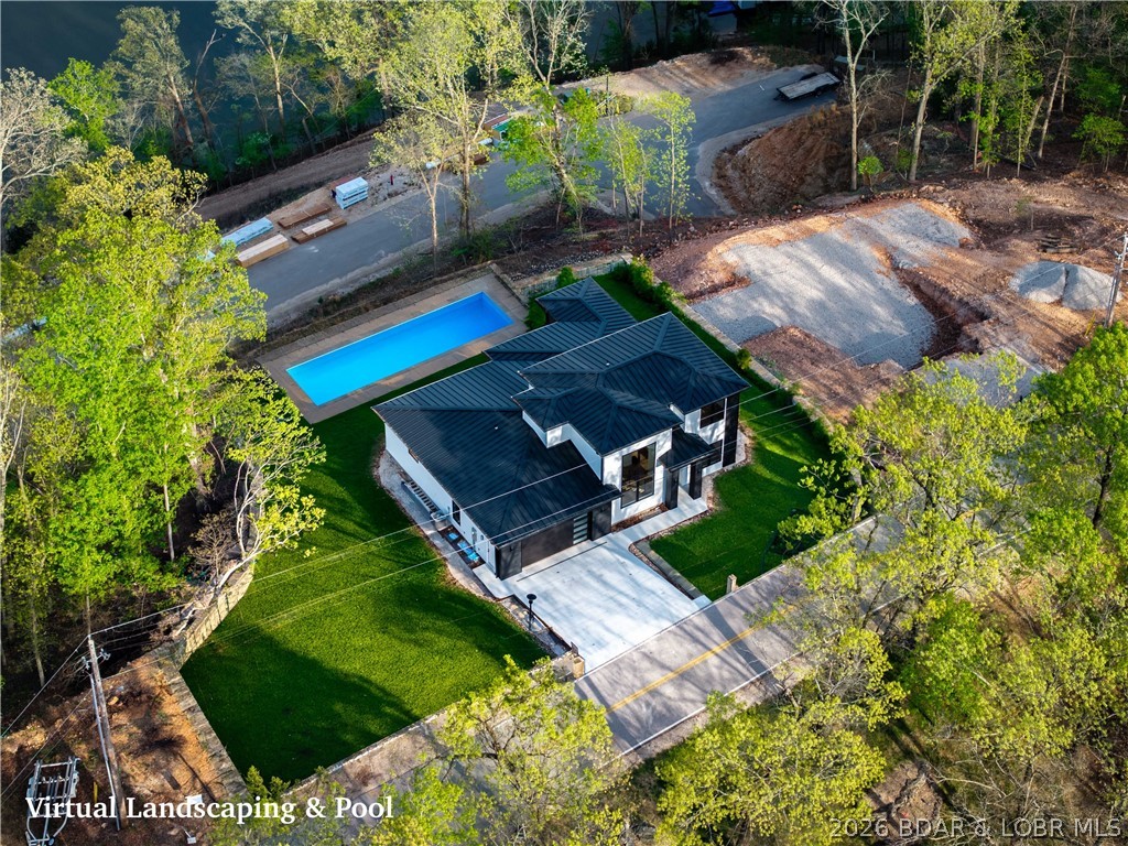 Luxury isn't just what you see—it's how a home is built. This exceptional new construction with lake views at the 3MM of the Osage showcases outstanding craftsmanship, premium materials, and thoughtful design throughout. Located down HH minutes from the Strip, waterfront dining, shopping, and entertainment, this nearly 3,000 sq ft home offers 5 bedrooms, 3.5 baths, and 2 private ensuites. A dramatic floating staircase and wall of Anderson windows and doors fill the home with natural light and capture beautiful lake views. The designer kitchen features a waterfall island, quartz and quartzite countertops, black and gold finishes, and Frigidaire Gallery appliances with a 36" gas cooktop. The primary suite is a retreat with Italian tile, heated floors, a soaking tub, and walk-in shower. Built for comfort with zoned HVAC, foam insulation, and a metal roof. Includes an oversized 2-car garage with golf cart space, available boat slips, room for a pool (additional cost), and a $20,000 landscaping allowance. Homes built to this standard are rare.