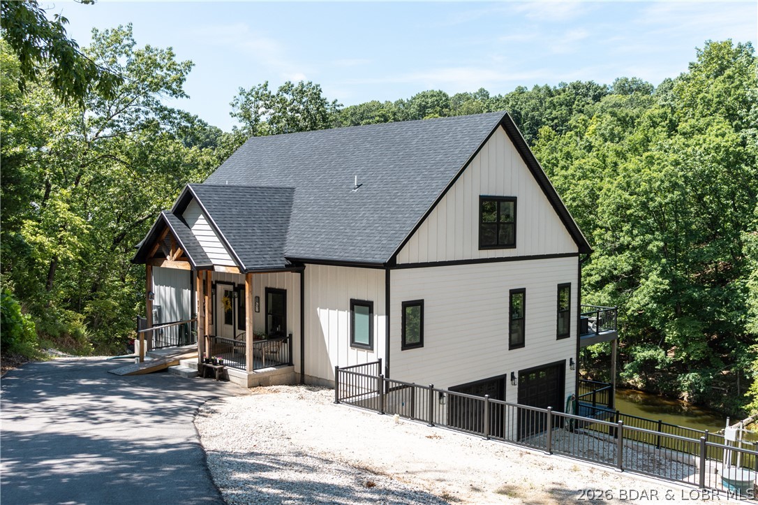 Experience the best of lakefront living at the 1-mile marker in the heart of Lake Ozark. This custom built 4-Bedroom, 4-Bath home, completed in 2024 offers approximately 3,325 Sq Ft of thoughtfully designed living space and an impressive 263' of lake frontage in a prime location. The Kitchen is a true gem featuring Quartz countertops, double wall ovens, and an expansive walk-in pantry. Flowing seamlessly into the main living area, you'll find soaring vaulted ceilings that create a grand feel with tons of natural light. You will love the cove protected waters, exceptional privacy, and unbeatable convenience - Just minutes by water or land to popular waterfront destinations and the iconic Bagnell Dam Strip. Designed for both entertaining and everyday comfort, this newer construction home combines modern finishes with the relaxed luxury of lake life. No HOA restrictions provides flexibility for full-time living, a second home getaway, or investment potential. Rarely does a newer custom lakefront home with this much frontage and this central location come available. PRICED UNDER APPRAISED VALUE PROVIDING INSTANT EQUITY!