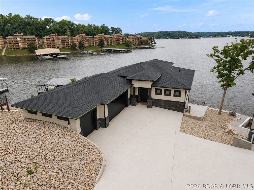 Experience modern luxury at its finest in this stunning new construction home overlooking breathtaking lake views. This home sit on a point with unmatched views of the main channel while at the same time being tucked away in a cove on a 3MM. Every inch of this thoughtfully designed residence was meticulously crafted to create the ultimate lakefront retreat. Offering three levels of exceptional living and entertaining space, this home is perfect for hosting family and friends. The dream-worthy primary suite features panoramic lake views, a spa-inspired bath with a freestanding soaking tub, oversized tiled walk-in shower, and a custom walk-in closet. Step outside to your private in-ground pool and take in the spectacular scenery, creating the perfect setting to relax or entertain. Ideally located down HH in Lake Ozark, you're just minutes from premier waterfront dining, shopping, golf, and local attractions. Additional highlights include a spacious 3-car garage and luxury finishes throughout. Whether you're searching for a full-time residence or the perfect lake getaway, this extraordinary home delivers an unmatched lifestyle you'll never want to leave.