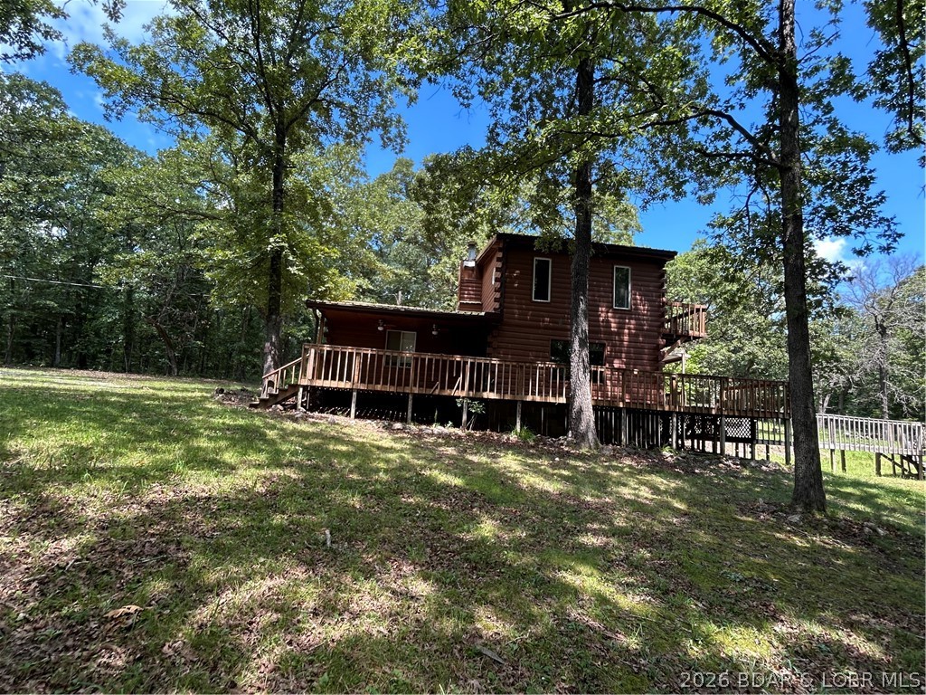 Rare opportunity to own nearly 34 acres in one of the Lake area's most sought-after recreational settings! Located just minutes from the State Park, Swinging Bridges, and the Grand Glaize Arm of the Lake, this 3-bedroom, 2-bath home offers 1,776 square feet and the chance to build instant equity. Whether you're searching for your next investment, hunting retreat, hobby farm, or private country escape, the possibilities are endless. The partially fenced and cross-fenced acreage is perfect for horses, livestock, or outdoor recreation and is teeming with wildlife. Property improvements include an inviting wraparound porch, cozy three-season room, permanent chicken coop with water and electric, RV carport, and a spacious workshop with room for boats, ATVs, tractors, or equipment. Bring your vision and a little elbow grease to unlock this property's full potential. Selling AS-IS, this is an outstanding opportunity to create something truly special.