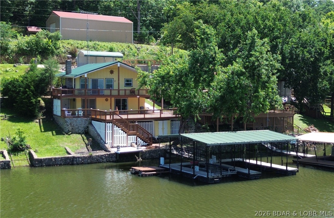Summer starts here! Escape to the Lake of the Ozarks and enjoy lakefront living at its best. Located at the 66-mile marker in a protected no-wake cove on the quieter side of the lake, this furnished 3-bedroom, 2-bath home offers approximately 1,600 square feet of comfortable living space and is ready for you to start making memories.
Spend your days boating, swimming, fishing, or simply relaxing on one of the two spacious decks overlooking the water. The covered dock features a concrete deck, two boat slips, one boat lift, two PWC lifts, and a swim platform, with deep water at the dock for convenient access throughout the boating season. Great fishing right off the dock is an added bonus! No HOA!!! 
When you're ready to explore, you'll appreciate the nearby marina, restaurant, and bar just around the corner. Whether you're looking for a full-time home, weekend getaway, or vacation investment, this move-in-ready property is ready to enjoy. Just pack your bags and start living the lake life!