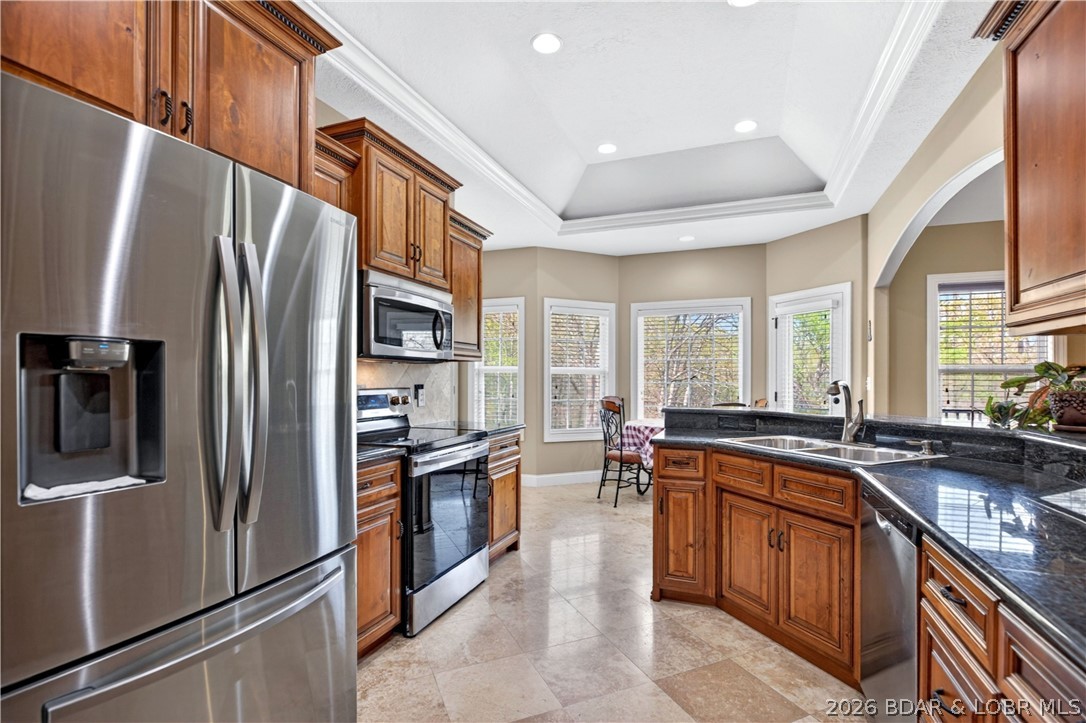 Tucked into the peaceful Deer Path Estates community, 132 Antler Point in Linn Creek offers comfortable one-level living with the space and setting to truly feel at home. This 4-bedroom, 3-bath brick home features vaulted ceilings, an open main living area, and a bright kitchen and dining space designed for everyday living and easy gathering. The private primary suite offers a relaxing retreat, while the spacious deck overlooks a beautiful wooded backdrop and gently sloping yard. With a 3-car attached garage, .93-acre lot, and convenient access to Hwy 54, this property combines privacy, practicality, and a welcoming feel in the Camdenton School District. New roof May 2026!