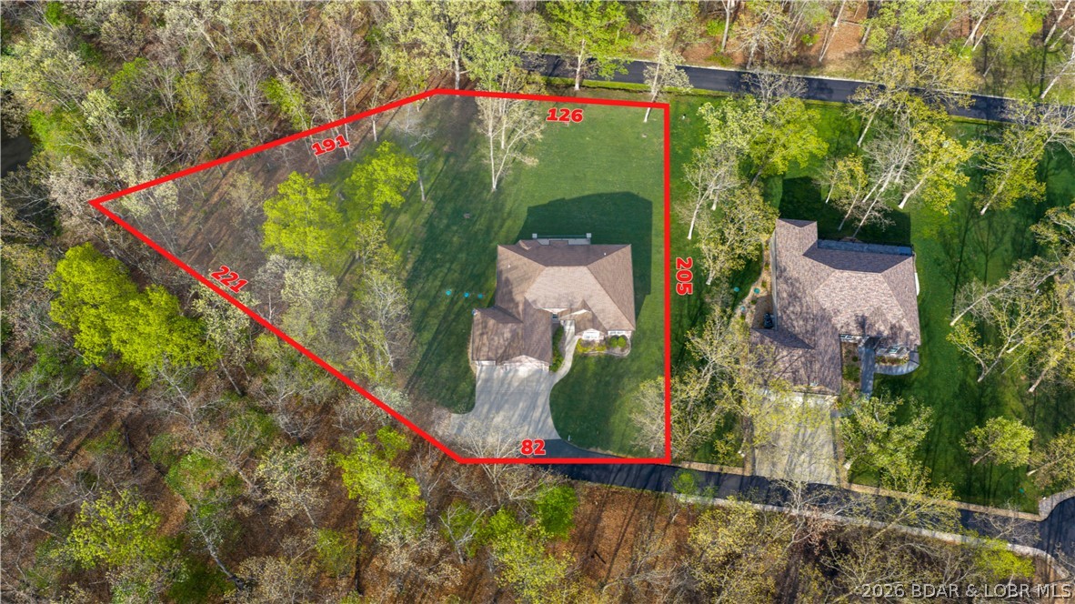 132 Antler Point, Linn Creek is tucked away at the end of Antler Point in Deer Path Estates, offering a peaceful setting on nearly an acre with plenty of room to relax, play, garden, or simply enjoy the privacy. This inviting 4-bedroom, 3-bath home features 2,066 sq ft of comfortable one-level living, a 3-car attached garage, and a beautiful wooded backdrop. Recent improvements include a new roof installed in May 2026, with a vapor barrier and dehumidifier being installed in the crawl space for added peace of mind. Inside, vaulted ceilings and an open layout create a bright, welcoming feel, while the kitchen and dining areas flow naturally into the main living space for everyday life and entertaining. The private primary suite offers a walk-in closet and bath, while three additional bedrooms provide flexibility for family, guests, an office, or hobbies. Step outside to the deck and enjoy the quiet setting, extra breathing room, and privacy that come with this end-of-road location. With community water, Spectrum internet, Camdenton Schools, and convenient access to Hwy 54, this home blends space, comfort, recent updates, and an easy Lake of the Ozarks lifestyle.
