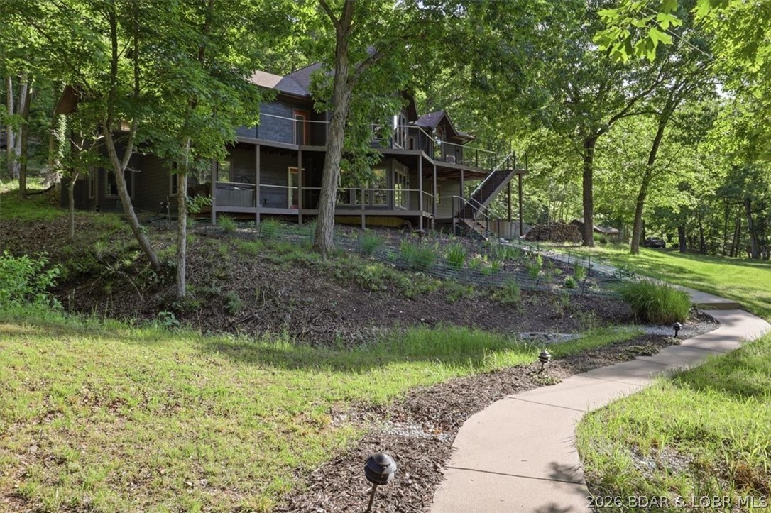 Tucked into the trees on over 8 acres at the 47MM in cove, this one-of-a-kind lake retreat blends privacy, character, and functionality in a way that’s hard to find. With over 3,500 sqft, 3 bedrooms, 2.5 baths, and main level living, the home is filled with architectural charm including soaring tongue-and-groove ceilings, walls of windows, warm wood finishes, and a see-through gas fireplace connecting the spacious kitchen and vaulted living area. The spacious kitchen offers lots of storage with a pantry and plenty of cabinets. The remodeled primary suite adds a more modern luxury feel with a custom walk in shower and walk. in closet. Two bedrooms with adjoining bath, second living room with wood stove, and large storage room make up the lower level. A three seasons room/greenhouse, lakeside decks on both levels, and gentle yard give tons of entertaining space. Walk down to an incredible 4-slip dock setup with room to hangout, multiple dock sheds, and an outstanding view. Attached 2-car garage plus a detached 30x40 heated shop with plumbing stubbed and 220 to make the perfect workshop. No HOA, fiber internet available, and nightly rentals allowed!