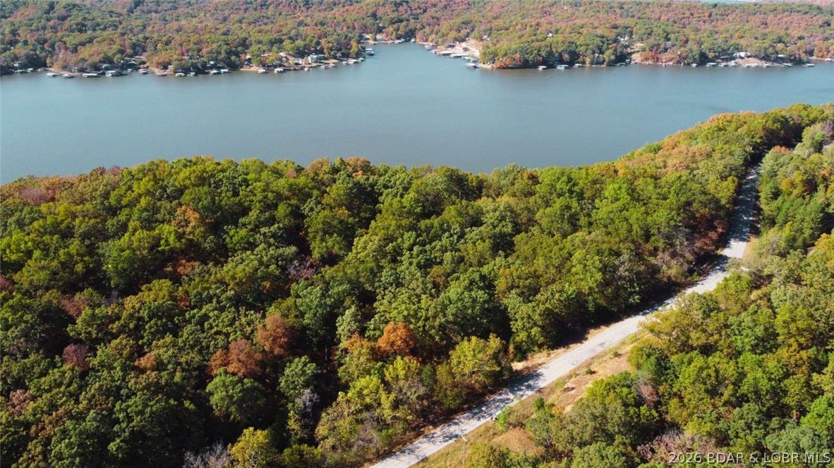 2.1 wooded bluff acres with direct river frontage on Coffman Bend Dr in Climax Springs, Camden County. This is the kind of property that stops you in your tracks, with paved road frontage, mature trees, natural brush, and the river right at the western edge of the parcel. Whether you are picturing a cabin with a river view, a recreational retreat, or a permanent residence surrounded by nature, the setting is already there. 
R-1 Residential zoning. Mobile homes permitted at least double wide, no more than 10 years old, placed on foundation. Tiny homes permitted. Short-term rentals allowed. Camping not permitted. RVs not allowed. No time limit to build. No HOA.
Terrain is gently sloped with elevation ranging from approximately 740 to 820 feet. Power available nearby along the eastern road border through Southwest Electric Cooperative, less than 80 feet away. Well installation required for water. Septic installation required. Propane for gas. Not in a flood zone per FEMA. Rear setback is 0 feet facing the river but at least 1 foot above base flood elevation required. Front setback 15 feet, side setback 10 feet. Owner fin options available. Reach out today to make it yours!