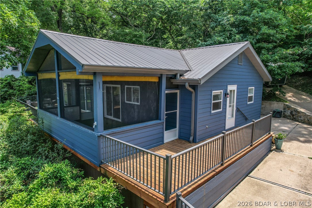 Beautifully updated lakefront home with a private dock, workshop, & spacious screened porch! Prime location at the 9 mile marker of the Big Niangua arm-well known waters for boating, fishing, water sports, swimming, & relaxing on the lake. Completely renovated in 2021, this exceptional retreat blends modern comfort with the charm of waterfront living. Updates include new siding, windows, doors, decking, flooring, paint, lighting, HVAC, electrical, plumbing, appliances, countertops, fireplace, & remodeled bathrooms, plus a new metal roof in 2024. Enhanced accessibility with a wheelchair ramp at the back entrance of the home. Lushly landscaped yard features an automatic sprinkler system & underground electric pet fence. An oversized 2-car garage provides ample space for vehicles & lake toys, while the finished heated & cooled workshop with concrete floors & overhead door is perfect for hobbies, projects, or extra storage. Enjoy easy access to the water from your private dock with boat lift & swim platform. No HOA fees or restrictions. Perfect full-time residence, weekend getaway, or investment opportunity, offering year-round lake living with exceptional updates & lasting appeal.