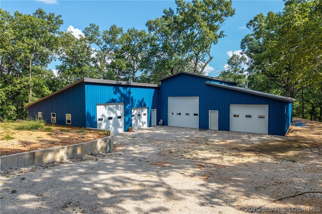Rare opportunity on 3.76 +/- connected acres (2.76 + 1 acre) on the North Shore! Offering two versatile barndominium/shop structures, mature shade trees, privacy and room for future expansion or green space. Conveniently located off Hwy W, approximately 7 minutes from Bagnell Dam and 1 mile from Village Marina. The 2.76 acre tract features a fully insulated 6,000 sf Quonset Hut with approx. 4,200 sf of shop space plus two finished apartments. The upper unit offers 2BR/1BA and approx. 1,500 sf; the lower offers 1BR/1BA and approx. 1,000 sf and is currently rented for $1,000/month with utilities included. A third area offers potential for a studio. Well, septic, HVAC and 200-amp service are in place. The 1 acre tract features a nearly 5,000 SF barndominium built this year and connected to an existing 20'x40' shop. Includes 1,000 sf of unfinished living space framed for 1BR/1.5 BA, plus 400-amp service. Enclosed shell is ready to finish to your vision. Call today for a private showing!