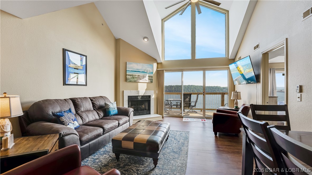 TOP-FLOOR PANORAMIC MAIN CHANNEL VIEWS set this exceptional two-level condo apart in The Ledges – Building 10. Designed to impress, the voluminous open floorplan is anchored by soaring two-story windows that flood the living space with natural light and frame unobstructed views of the main channel at the 21-mile marker. Step directly onto the brand-new deck to take in the lake action and unforgettable sunsets. The main level offers a generous dining area, kitchen with eat-at bar, and a tranquil lakeside primary suite with deck access and a spacious en-suite bath. A guest bedroom, full bath, and laundry with full-size units complete this level for everyday comfort. Upstairs, the loft-style third bedroom overlooks the dramatic lakeview windows and includes bonus living space—ideal for guests, kids, or additional lounging. One of the lake’s most sought-after and family-friendly communities, The Ledges features a sand beach, interior community pool, and a stunning point pool with bar area for enjoying the lake in style. Whether for personal enjoyment or investment potential, this top-floor retreat delivers. 10x30 slip included, 14x40 slip available to swap for extra, garage available.